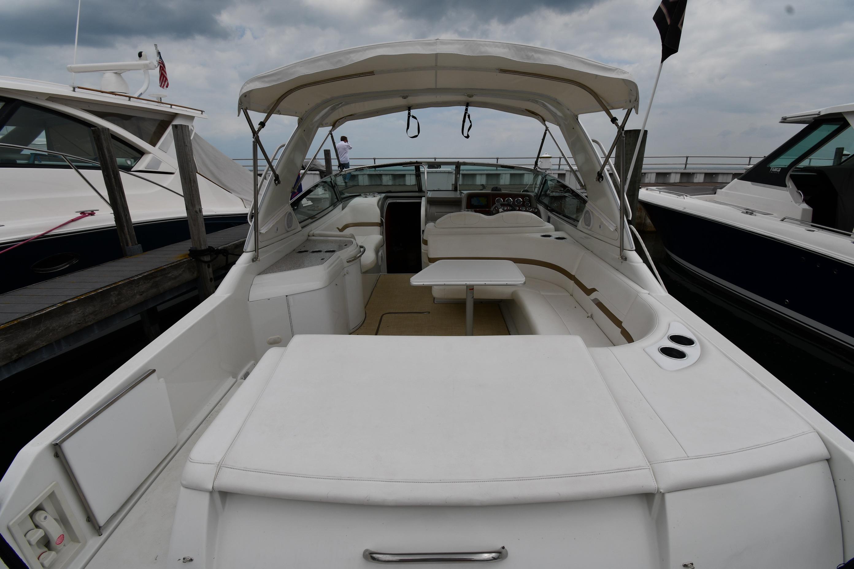 2004 Formula 330 Sun Sport boat docked, featuring spacious seating and canopy.