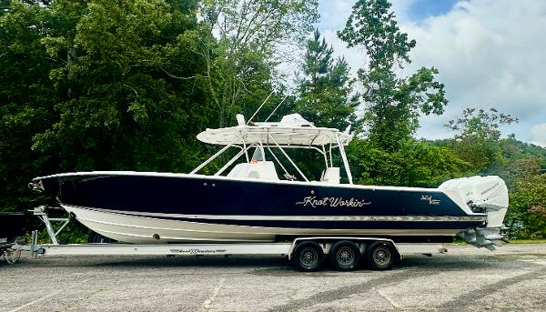 2008 SeaVee 390B boat on trailer, parked outdoors with lush green trees in the background.