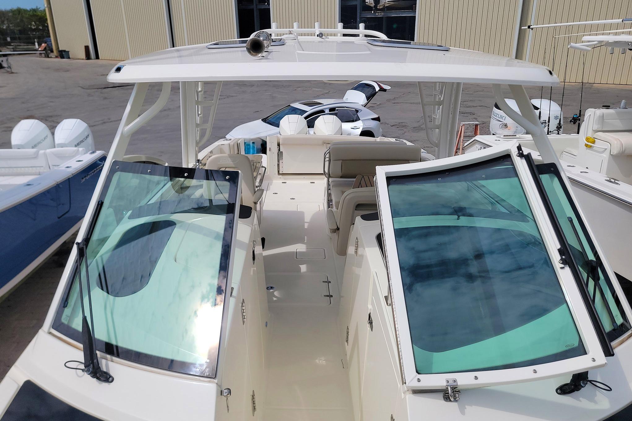 2022 Boston Whaler 320 Vantage boat with open cockpit and windshield, docked at marina.
