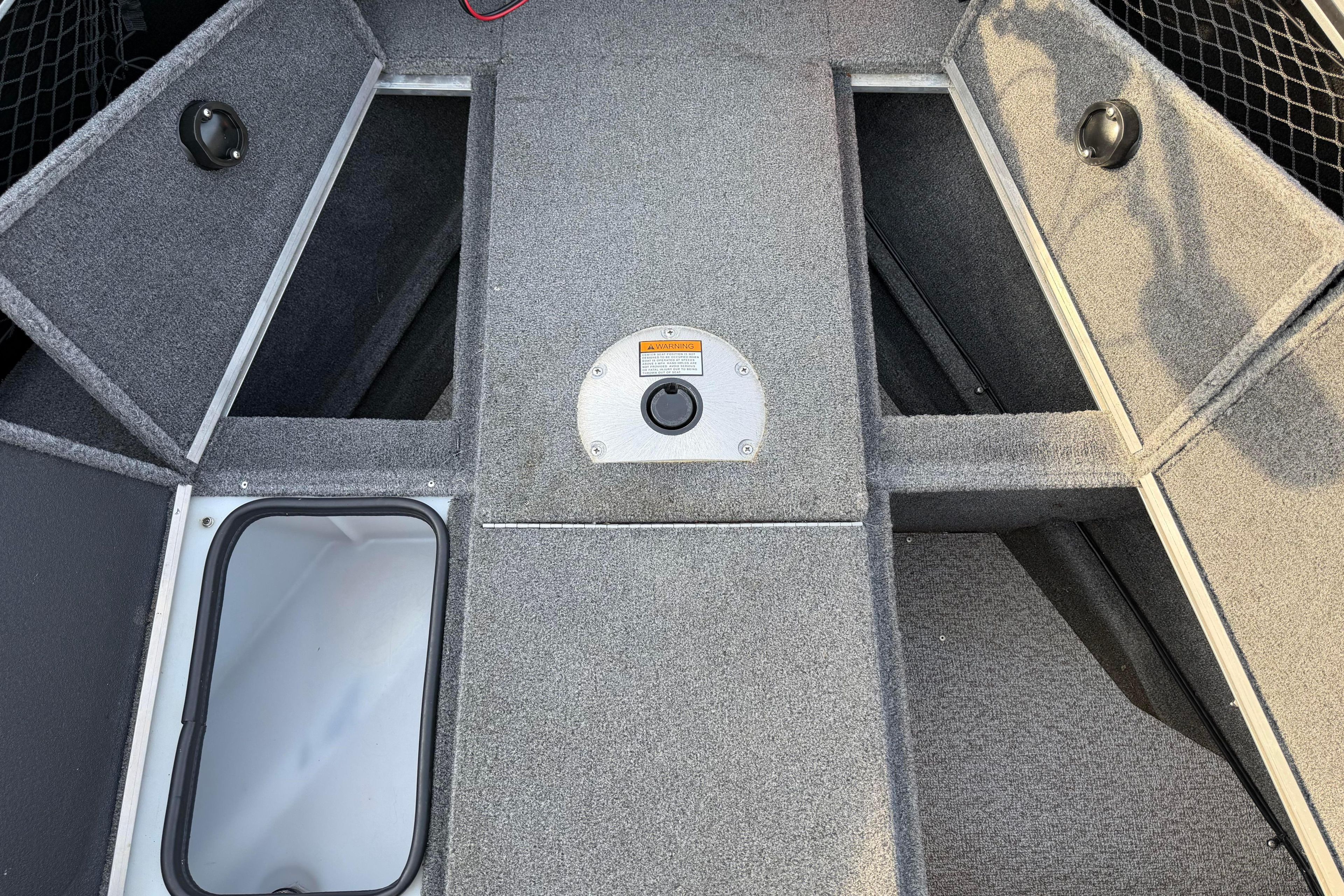 2019 Alumacraft Trophy 205 boat interior with storage compartments and carpeted flooring.