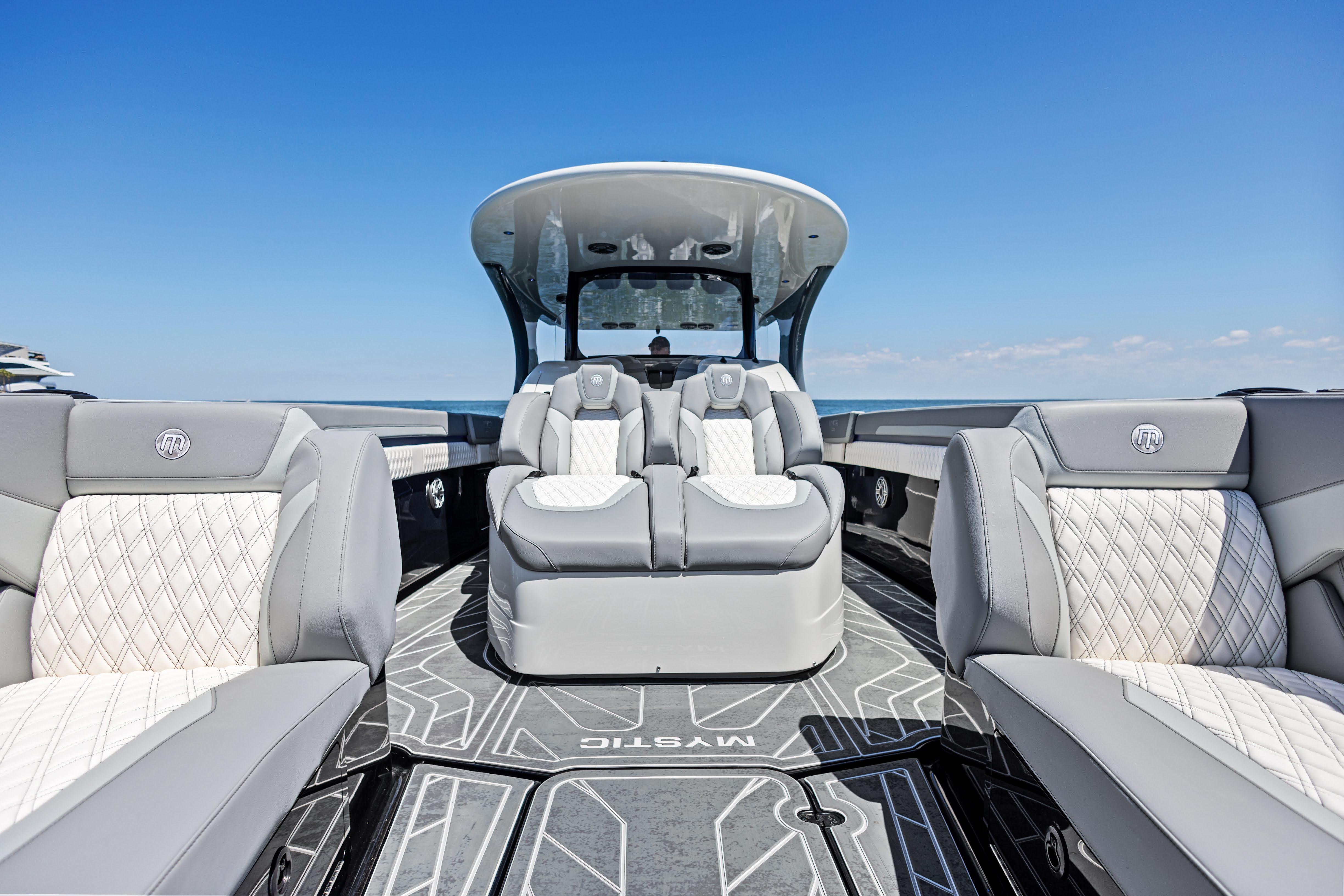 2026 Mystic Powerboats M4200 interior with luxurious seating and sleek design under clear blue sky.