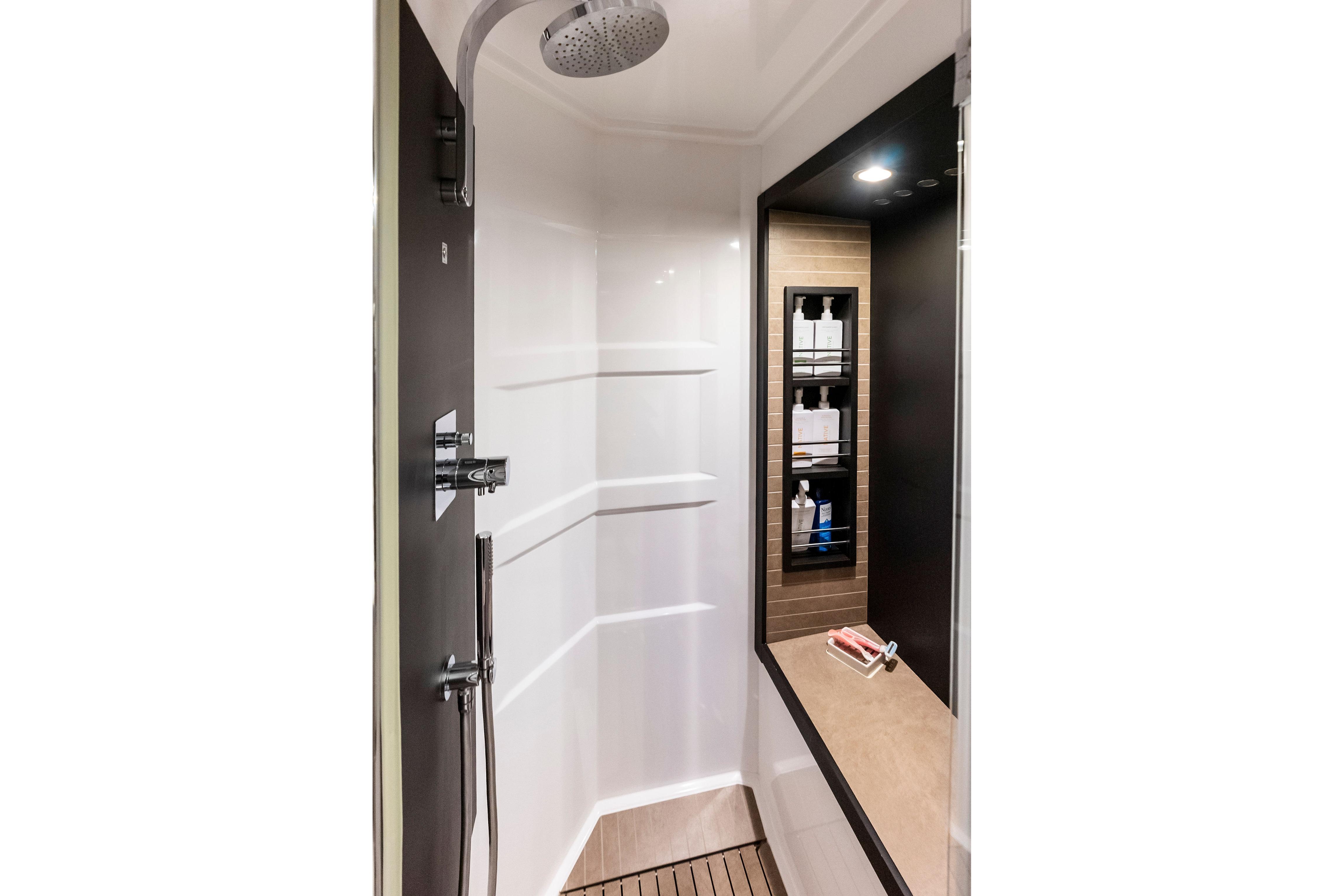 Luxurious shower area in 2020 Azimut 66 yacht, featuring modern fixtures and shelving.