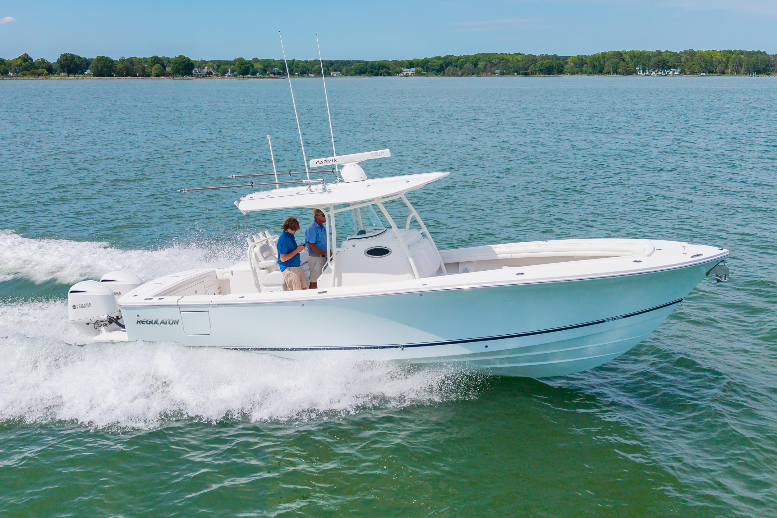 2019 Regulator 31 boat cruising on open water with two people onboard.