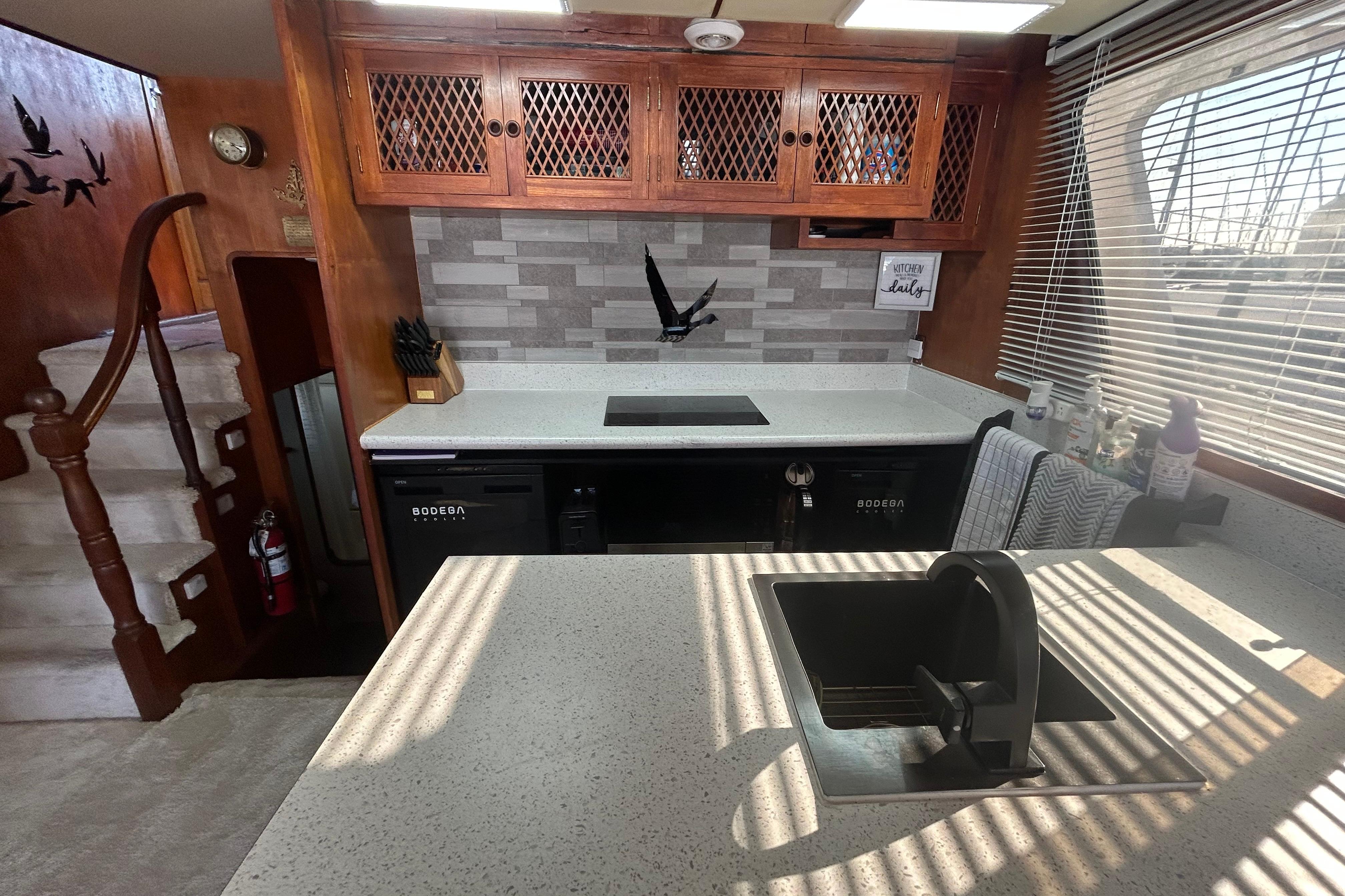 1981 Ocean Alexander 50 Pilothouse kitchen with modern countertops and wooden cabinetry.