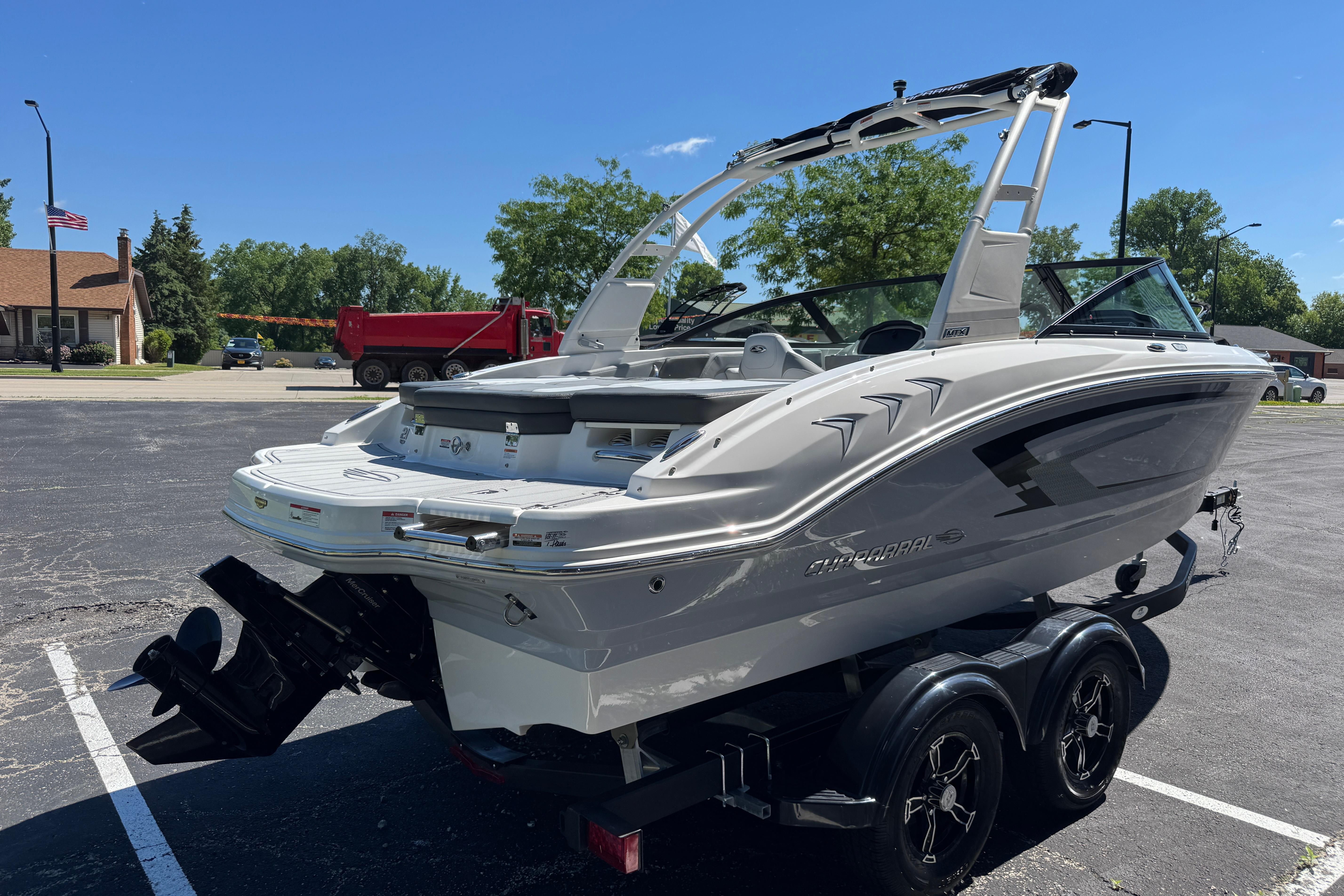 2026 Chaparral 21 SSi boat on trailer in parking lot, sunny day.