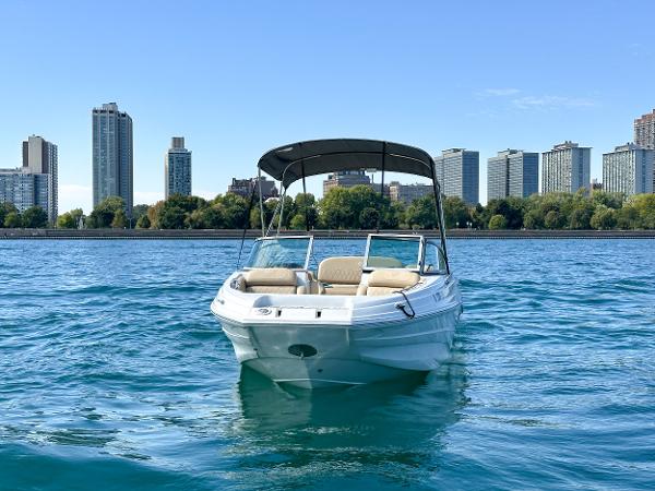 2023 Crownline 215 XS boat on water with city skyline in background.
