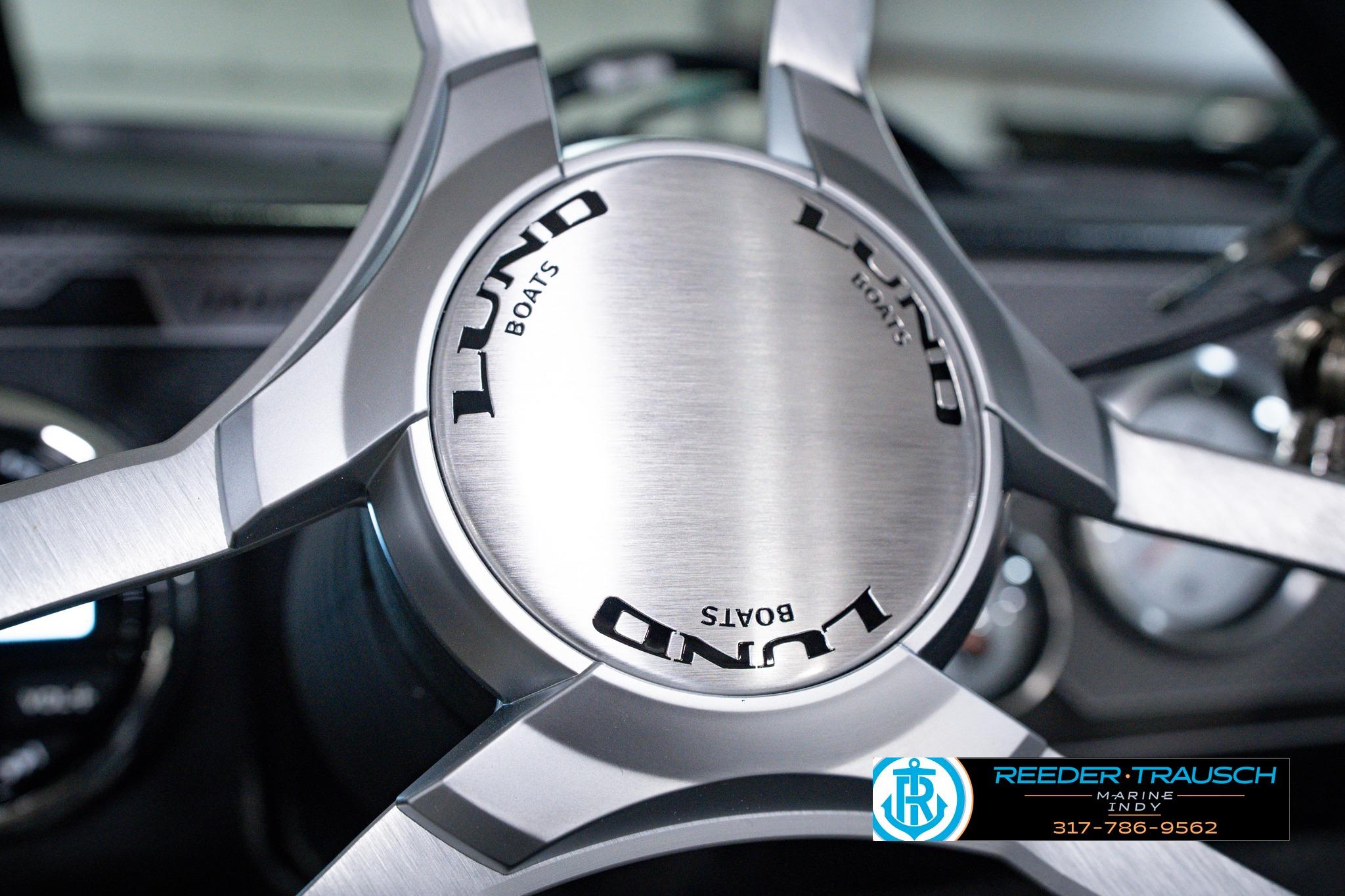 Steering wheel of 2026 Lund 1875 Impact XS SS boat, featuring sleek metallic design.