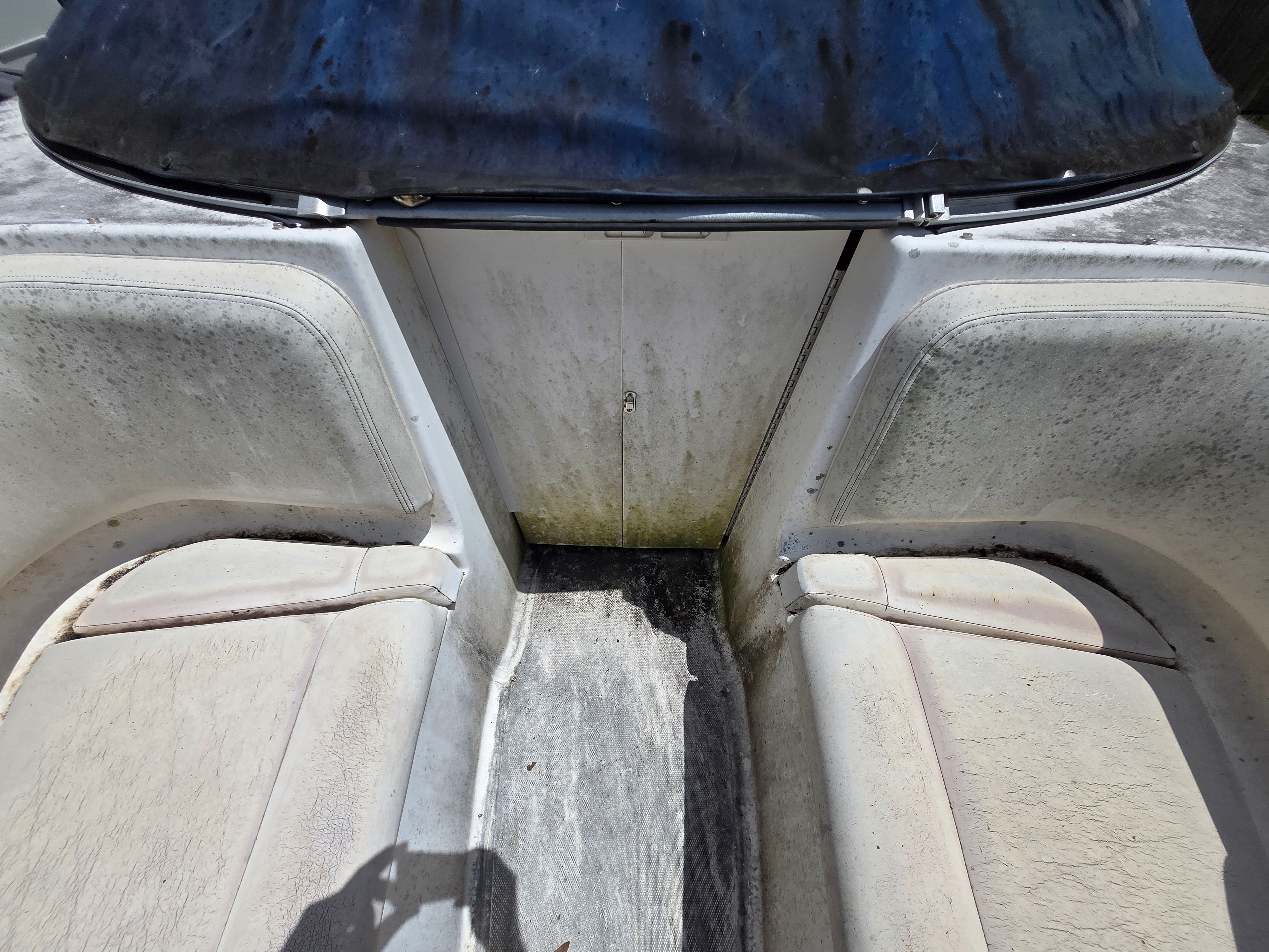 Interior of a 2006 Chaparral 220 SSi with worn seats and a dirty floor.