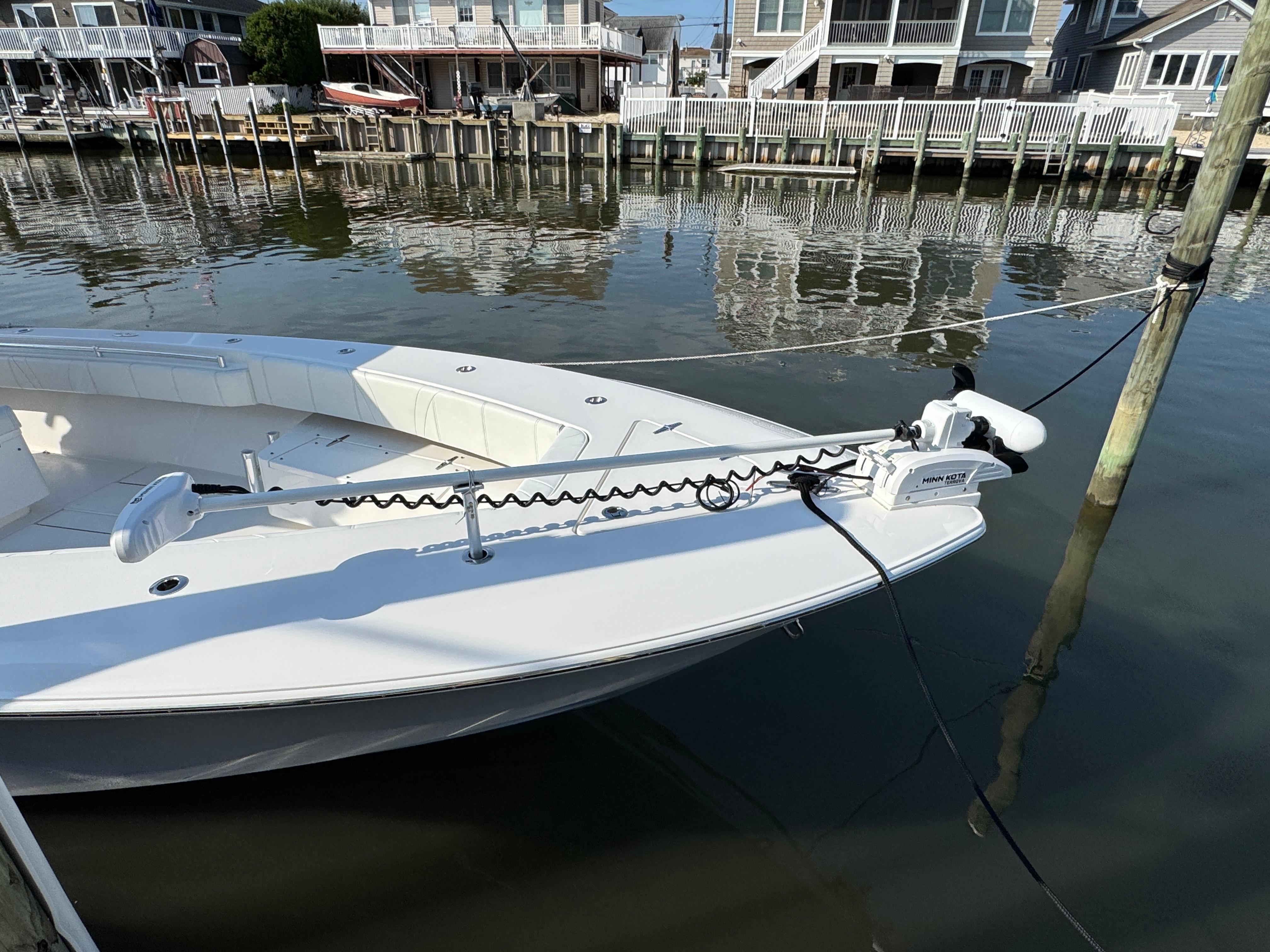 2022 Contender 32 ST boat docked in a marina, featuring a Minn Kota trolling motor.