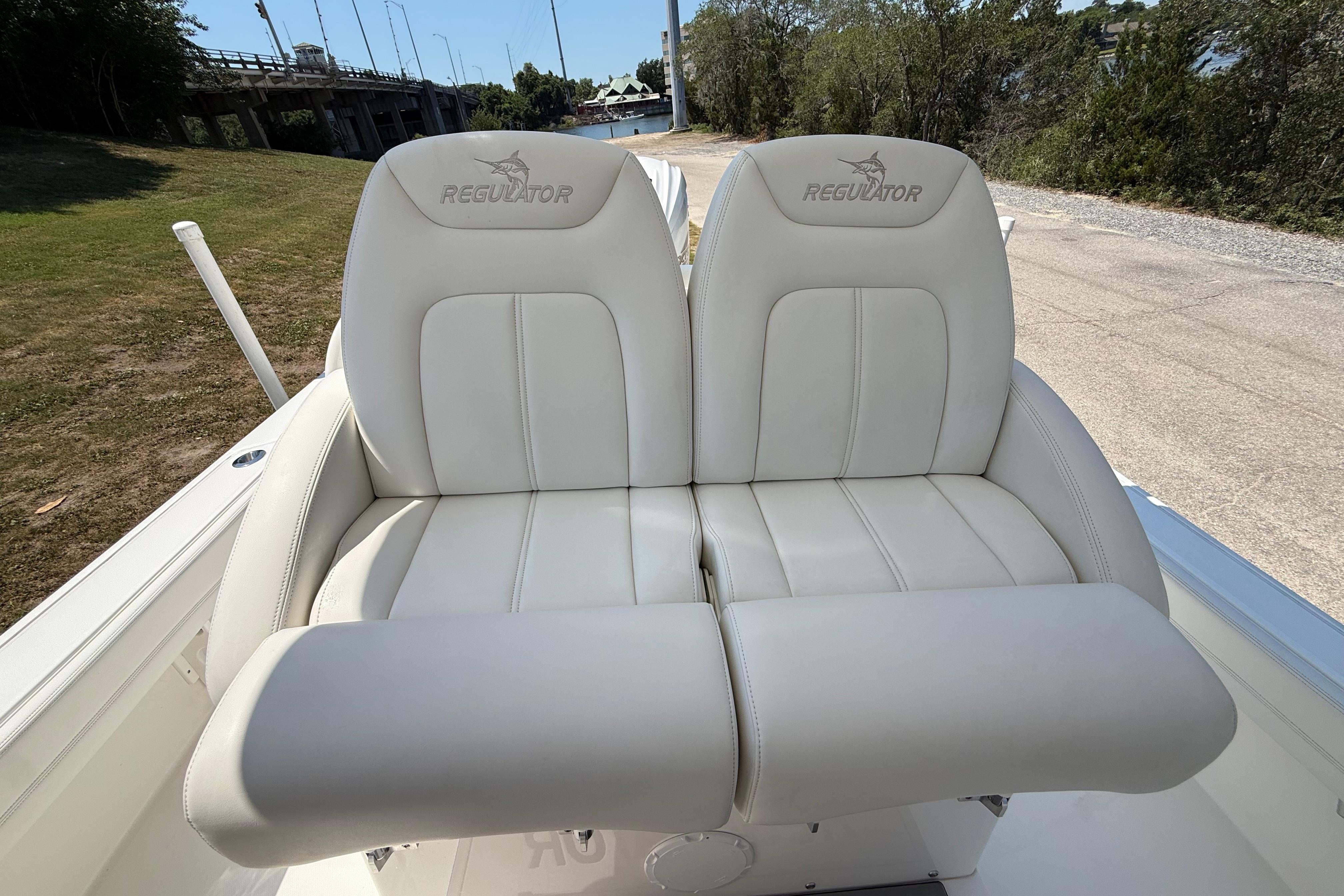 2023 Regulator 26XO boat seats, white leather, outdoor setting.