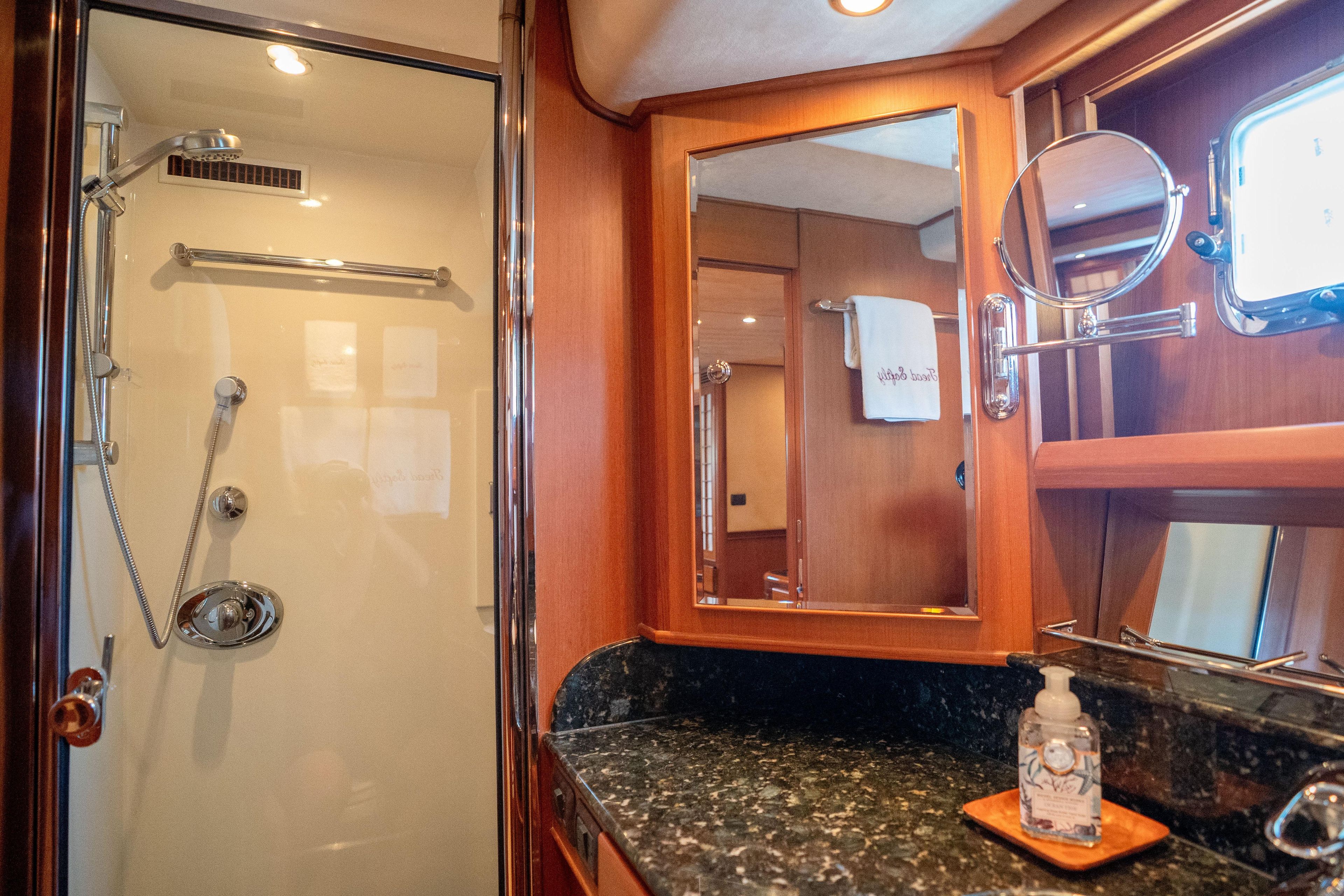 Luxurious bathroom interior of a 2006 Fleming 75 yacht, featuring a shower and vanity.