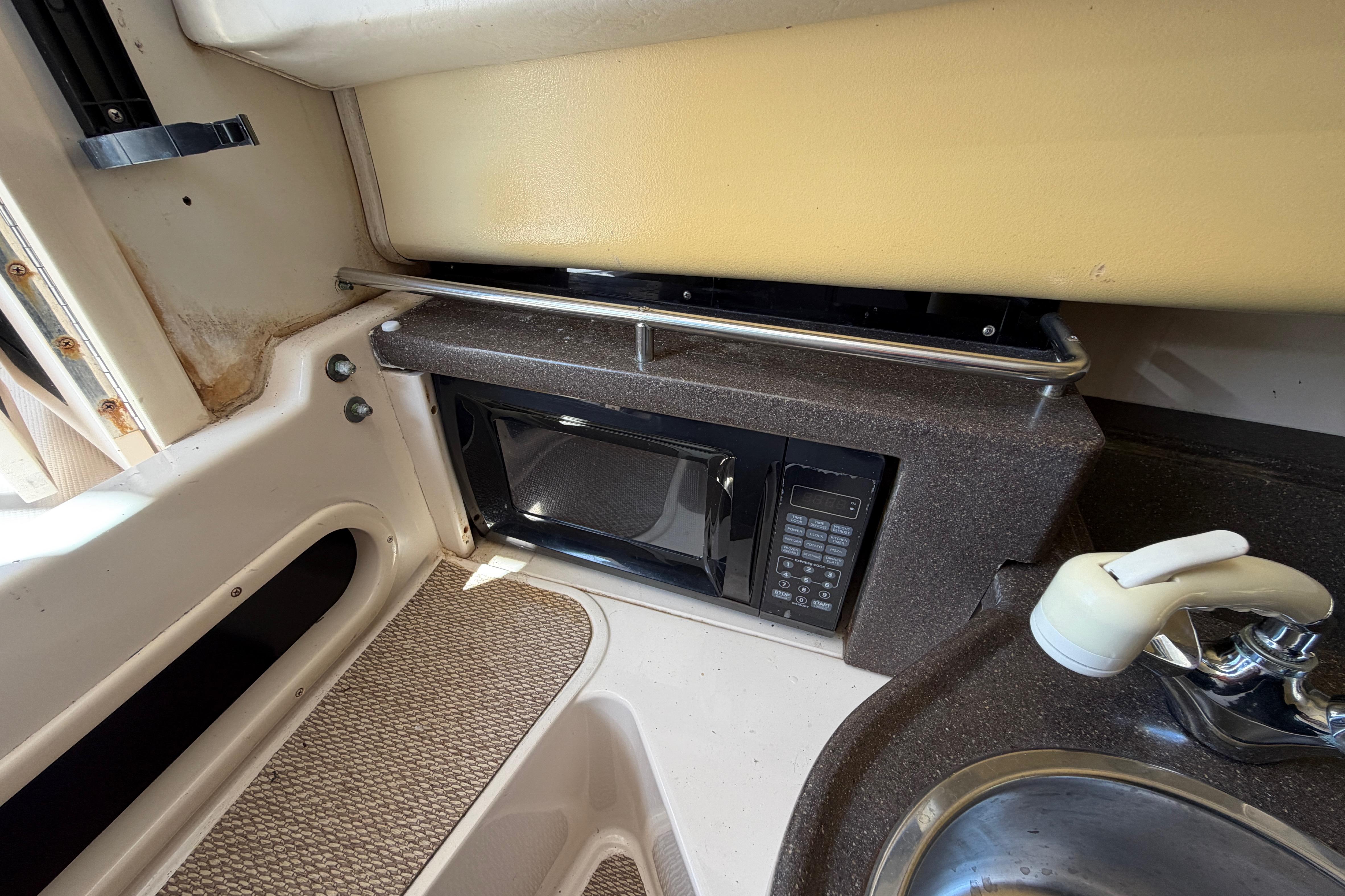 2006 Grady-White Sailfish 282 interior with microwave and sink in compact kitchen area.