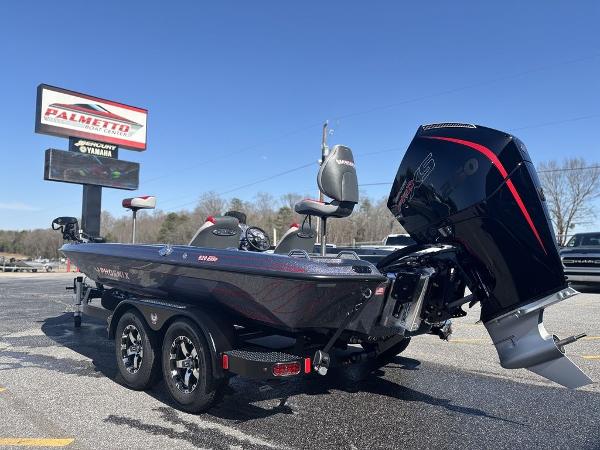 2025 Phoenix 920 Elite boat with powerful engine, parked outdoors under clear blue sky.