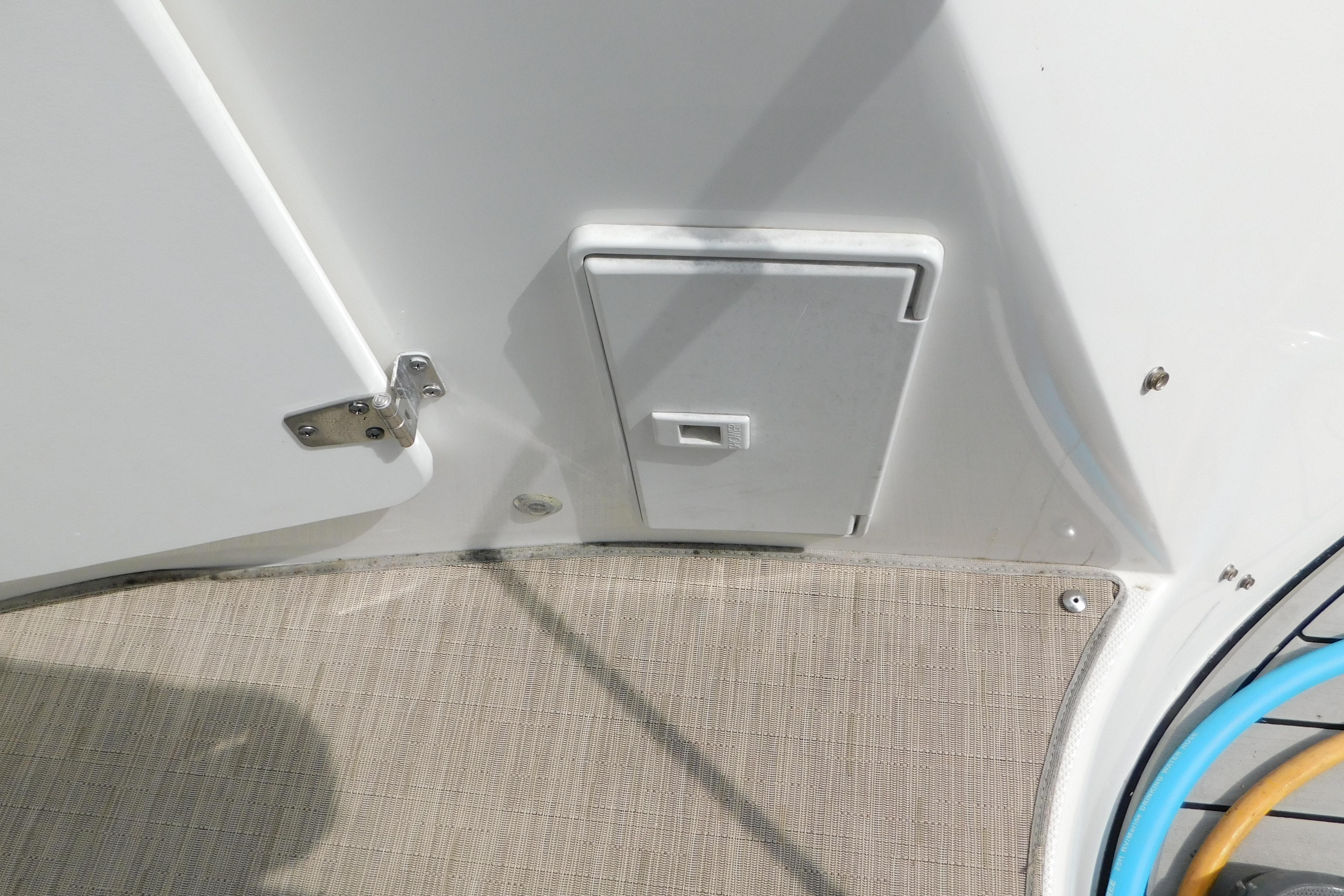 2017 Rinker EX 320 boat deck with storage compartment and latch.
