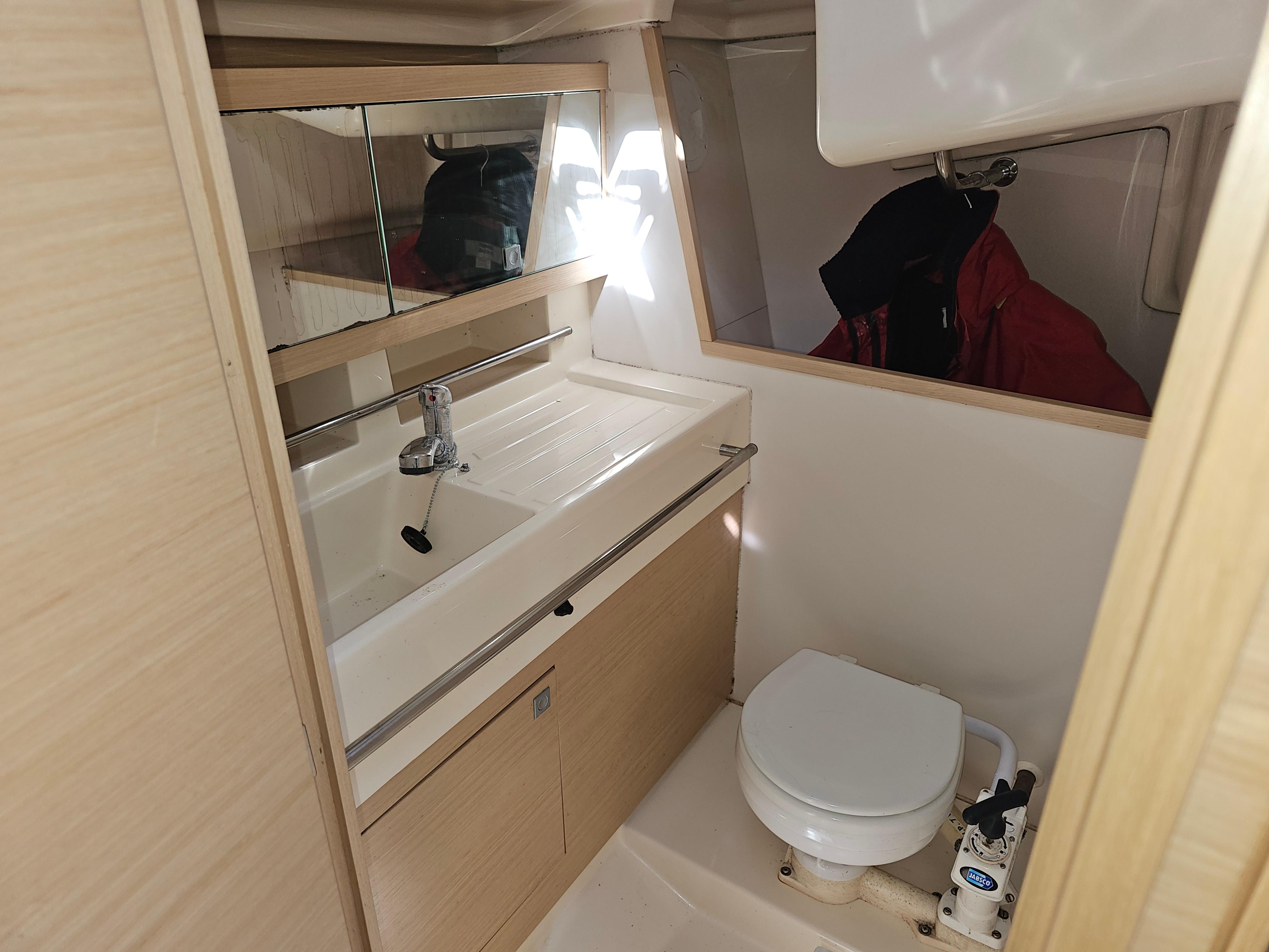2011 Elan 350 yacht bathroom with sink, mirror, and toilet in compact, modern design.
