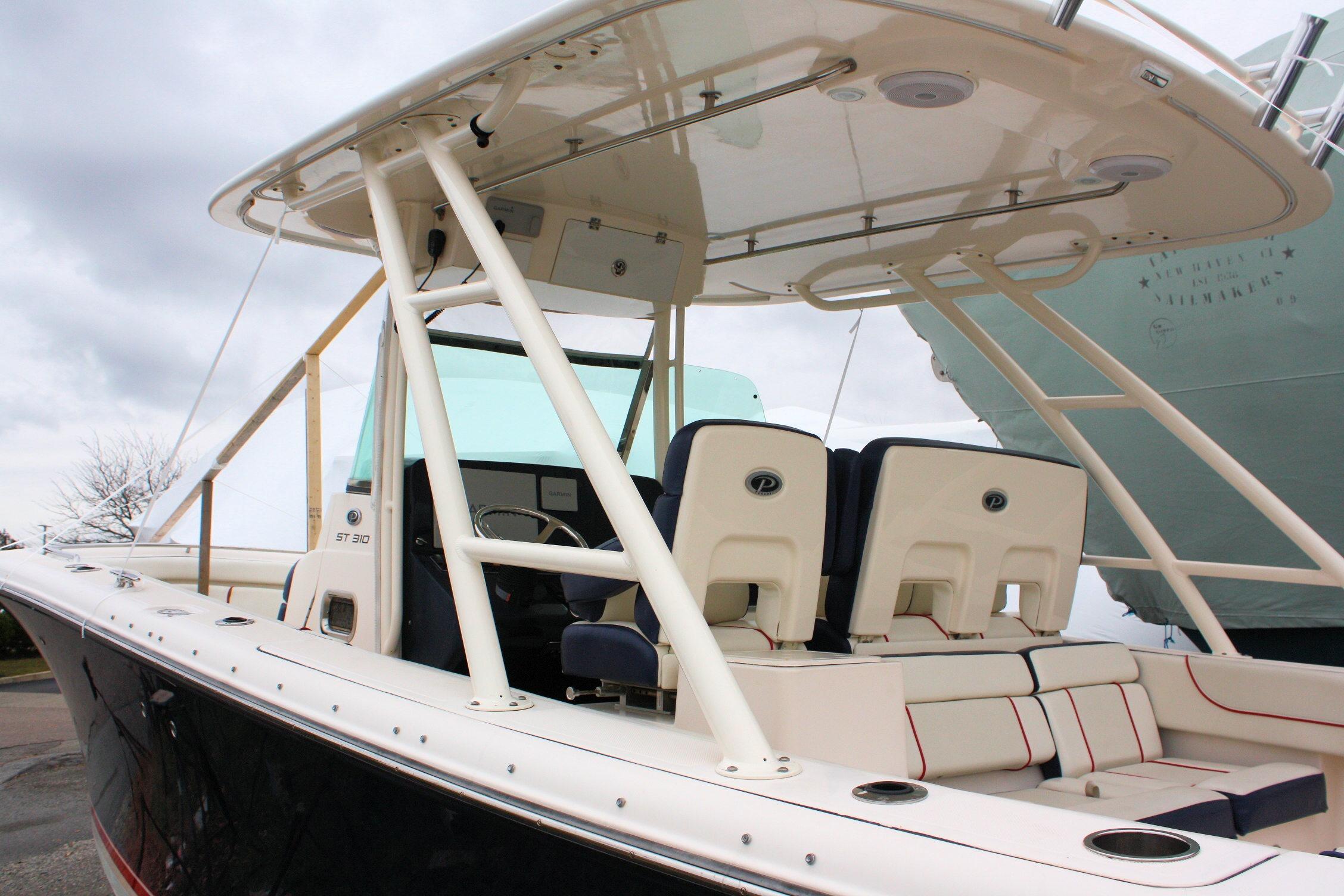 2013 Pursuit ST 310 Sport boat with seating and canopy, docked under cloudy skies.