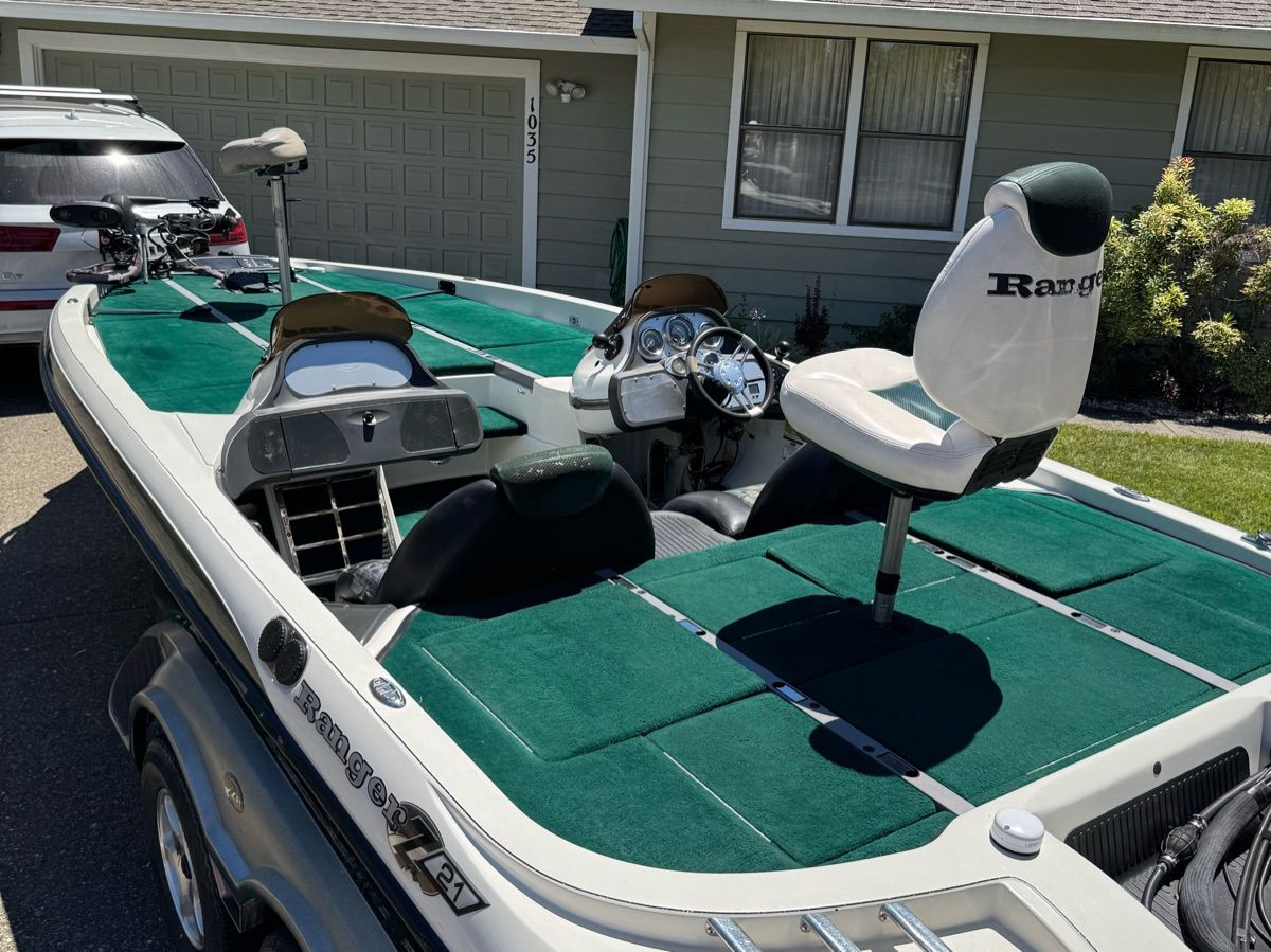 A 2005 Ranger Z-21 boat with green carpeting, two seats, and a steering console.