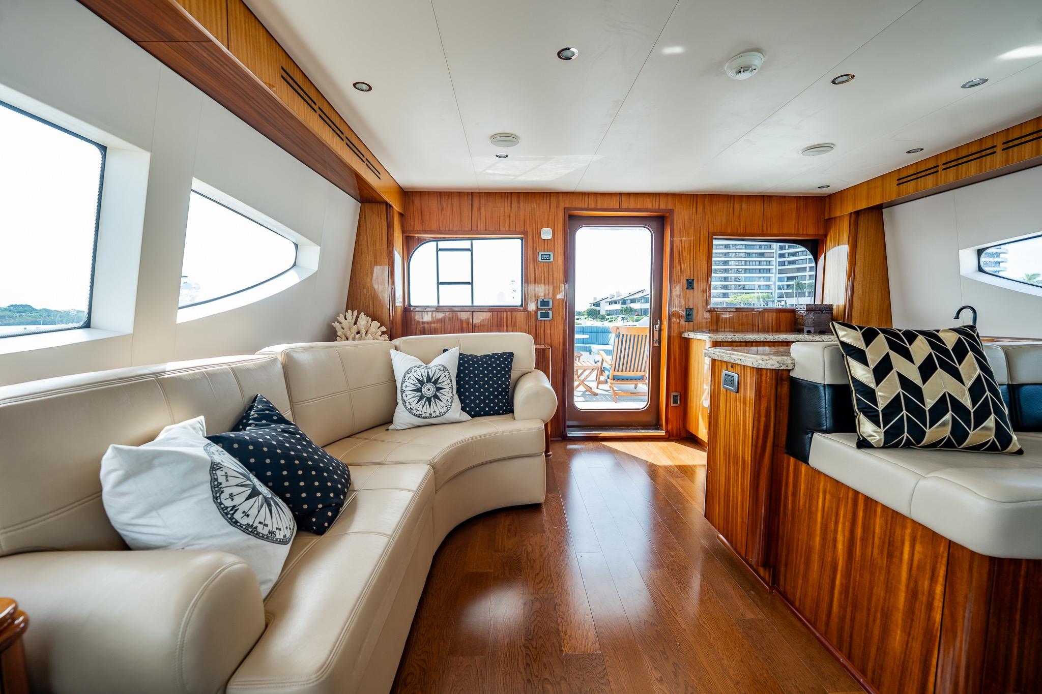 Luxurious interior of 2012 Hatteras 80 Motor Yacht with elegant seating and wooden accents.