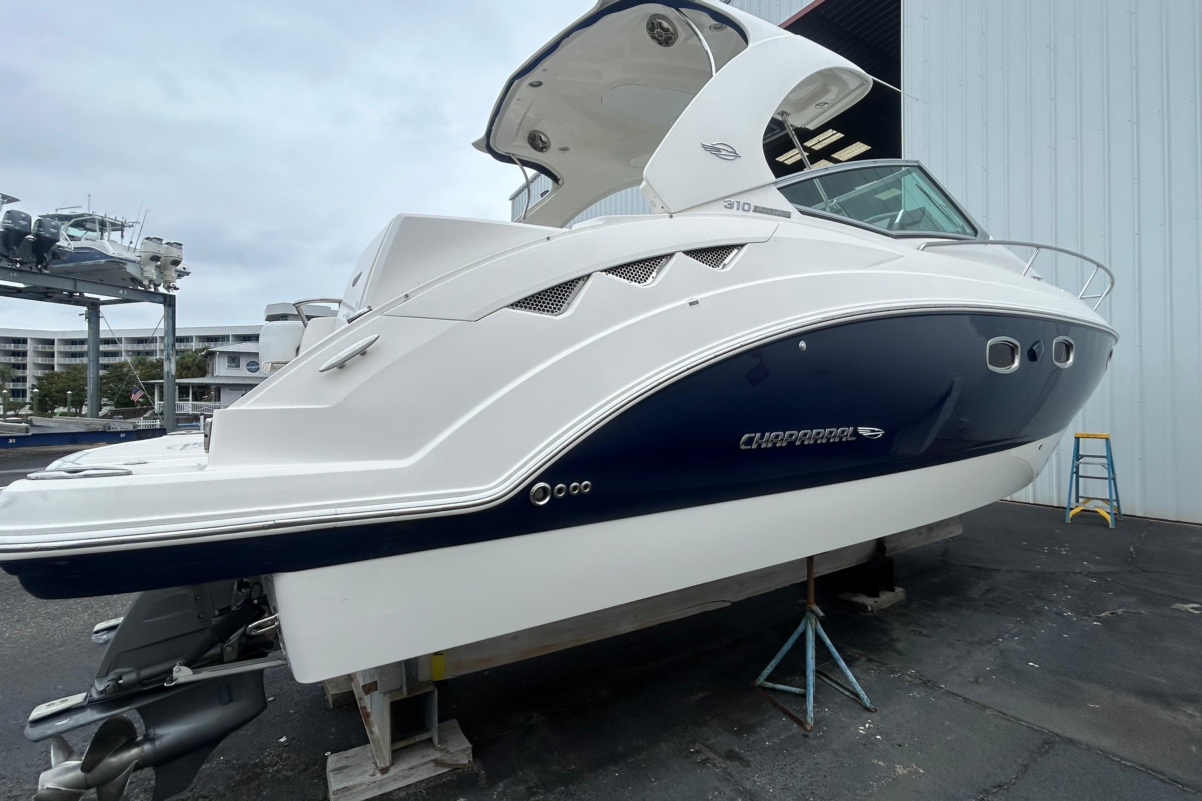 2014 Chaparral 310 Signature boat on dry dock, showcasing sleek design and modern features.