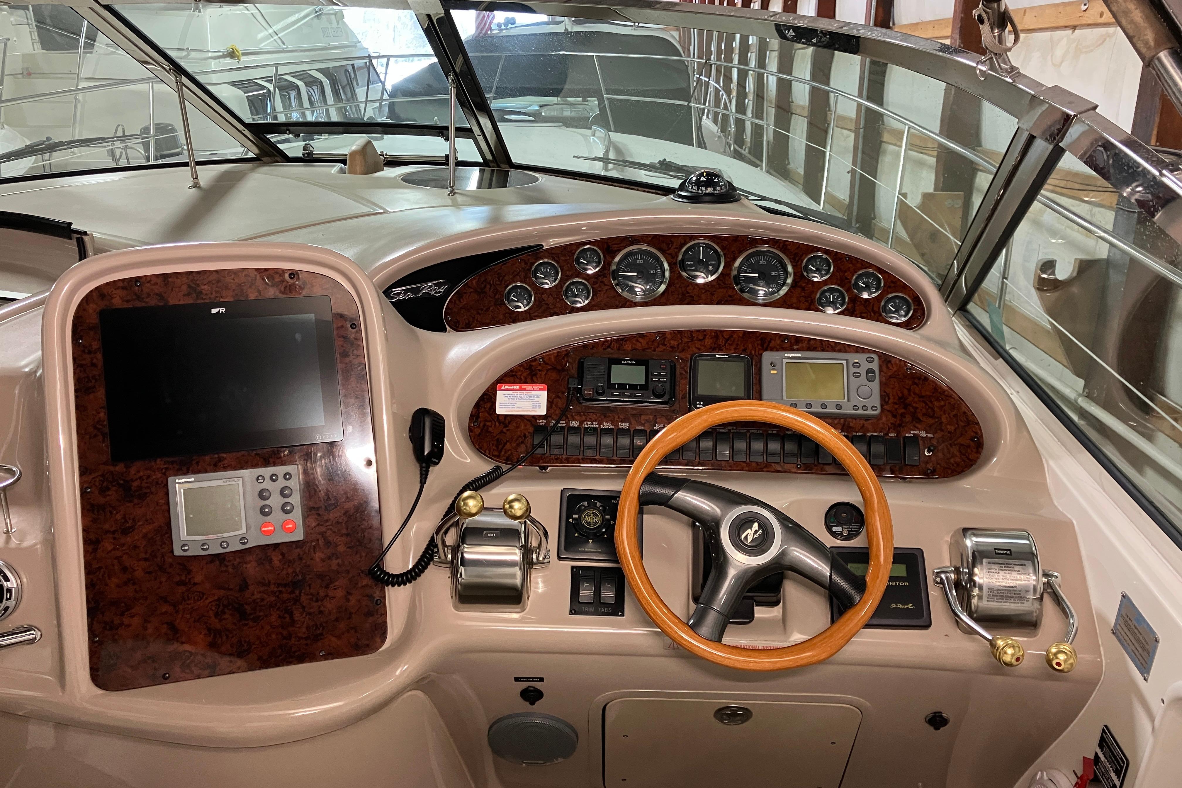 2002 Sea Ray 410 Sundancer helm with wood accents and modern navigation equipment.