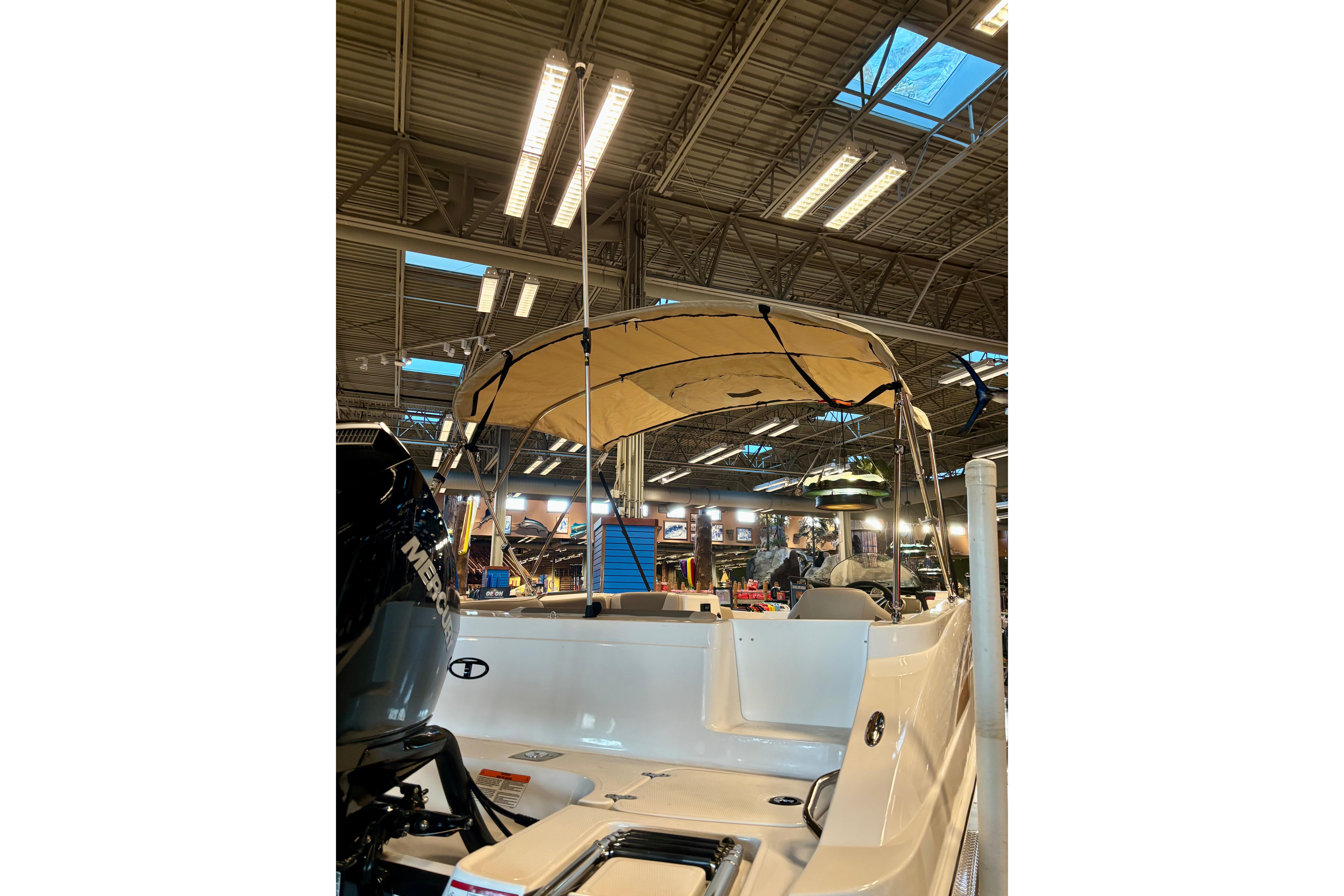 2026 Tahoe 2150 boat with canopy displayed indoors under bright lights.