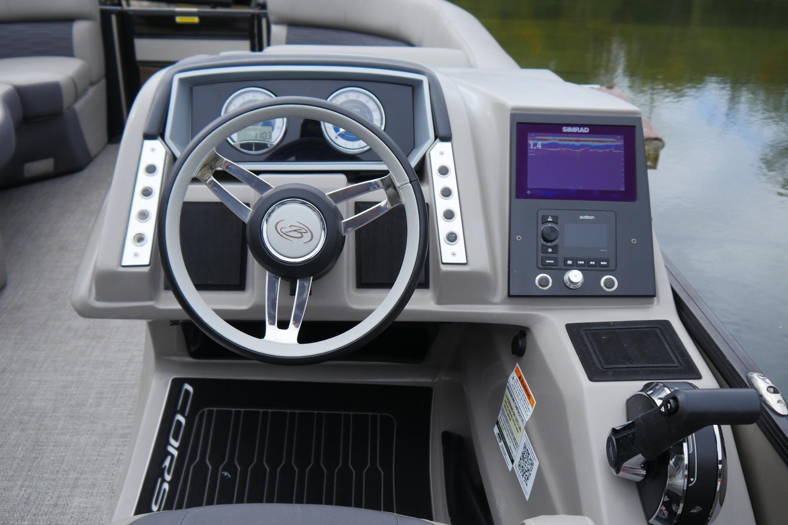 2023 Barletta CORSA 25UE boat dashboard with steering wheel and navigation display.