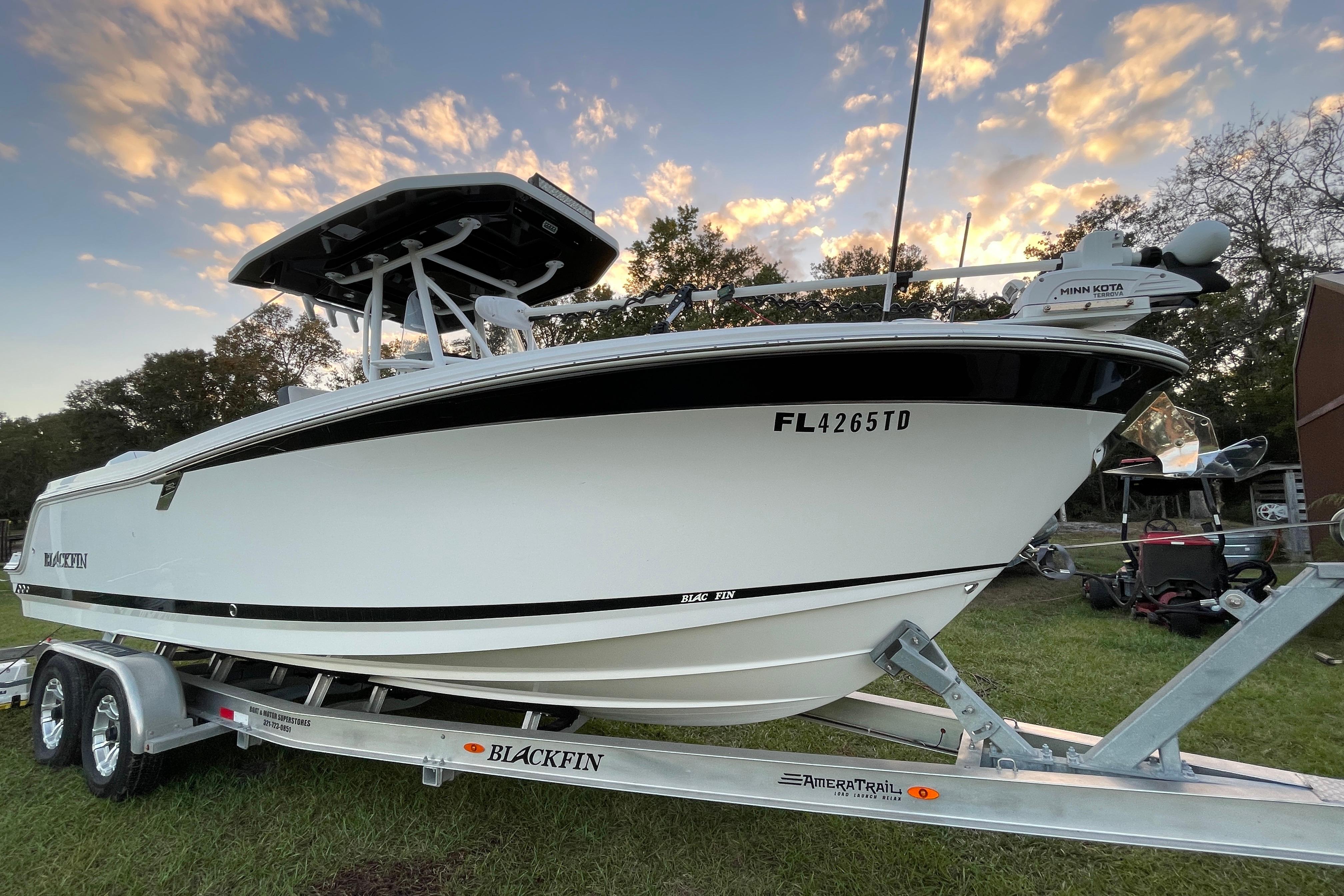 2022 Blackfin 252 CC boat on trailer at sunset, showcasing sleek design.