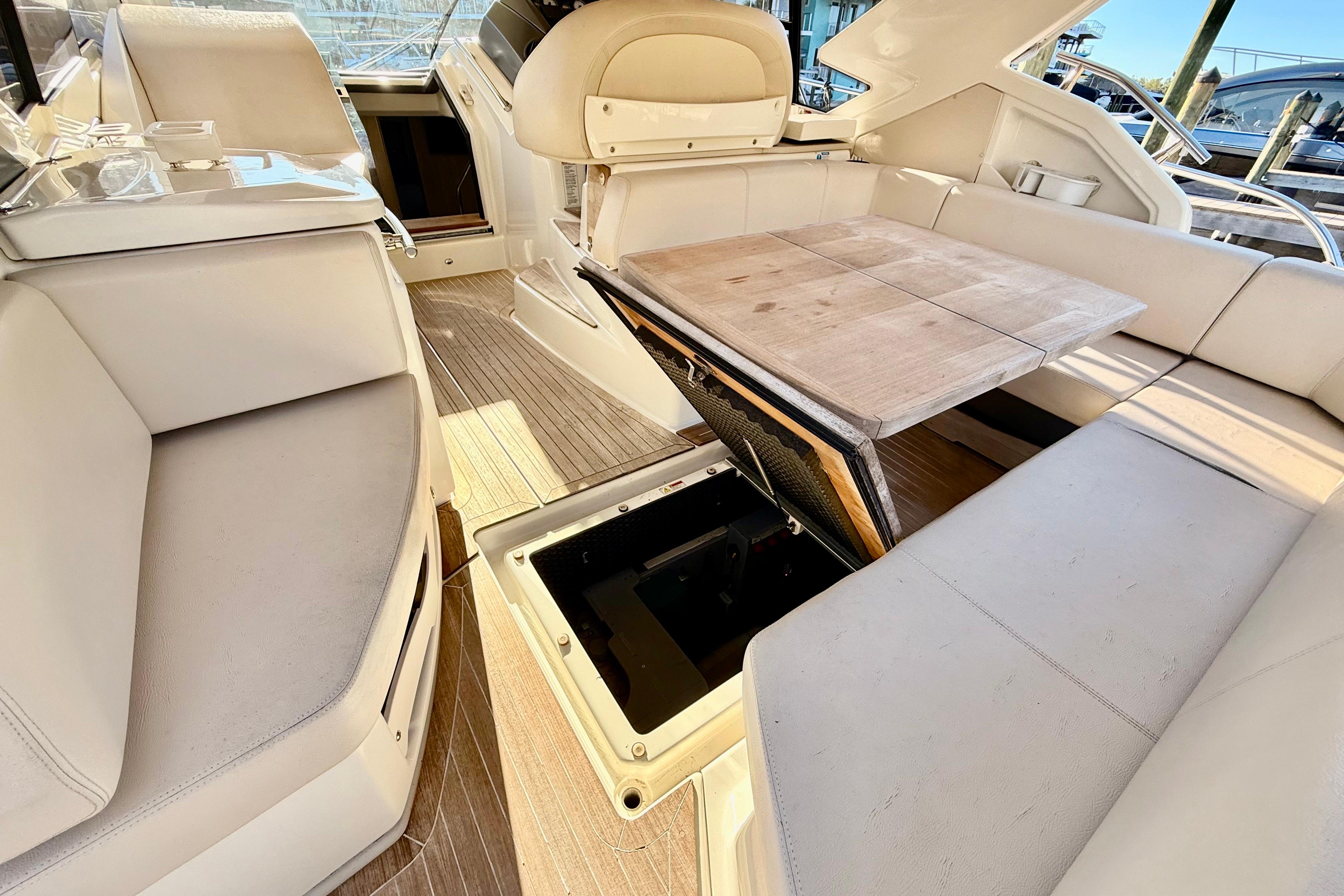 2016 Cranchi M44 HT yacht interior with beige seating and wooden table.