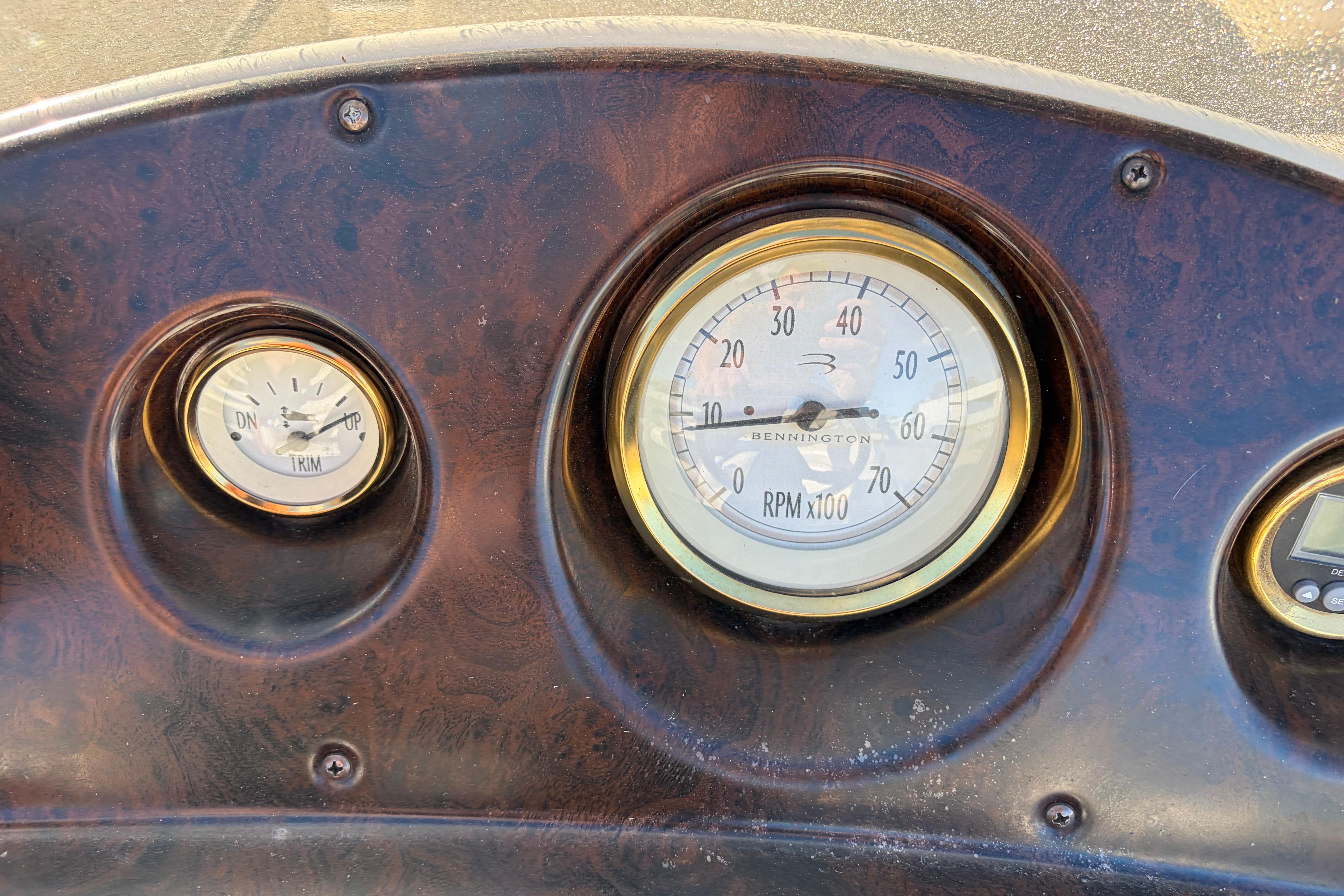 Dashboard of a 2003 Bennington 2250RSi boat with RPM and trim gauges.