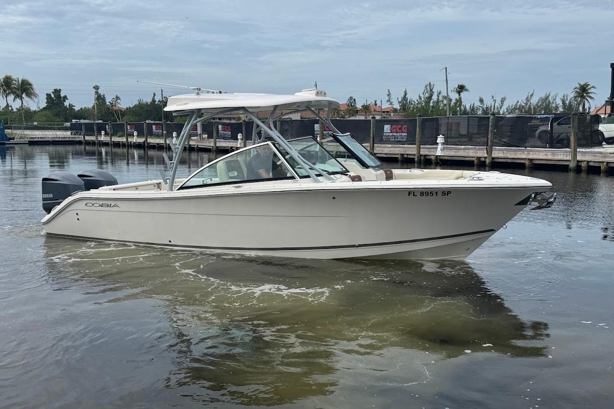 2020 Cobia 280 Dual Console boat docked in marina, calm water, overcast sky.