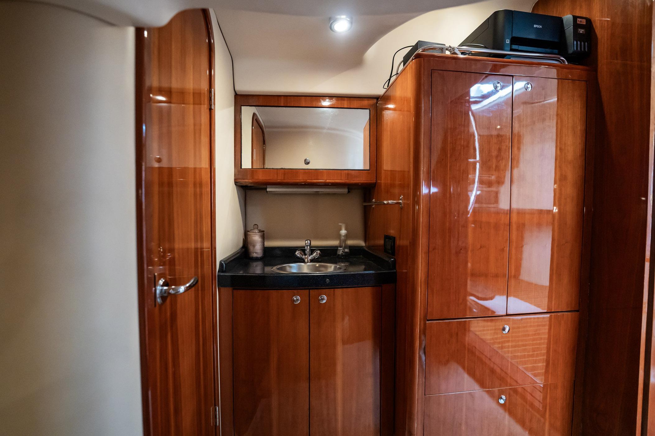 Luxurious 2008 Regal Commodore 4460 yacht interior with polished wood cabinetry and sink.