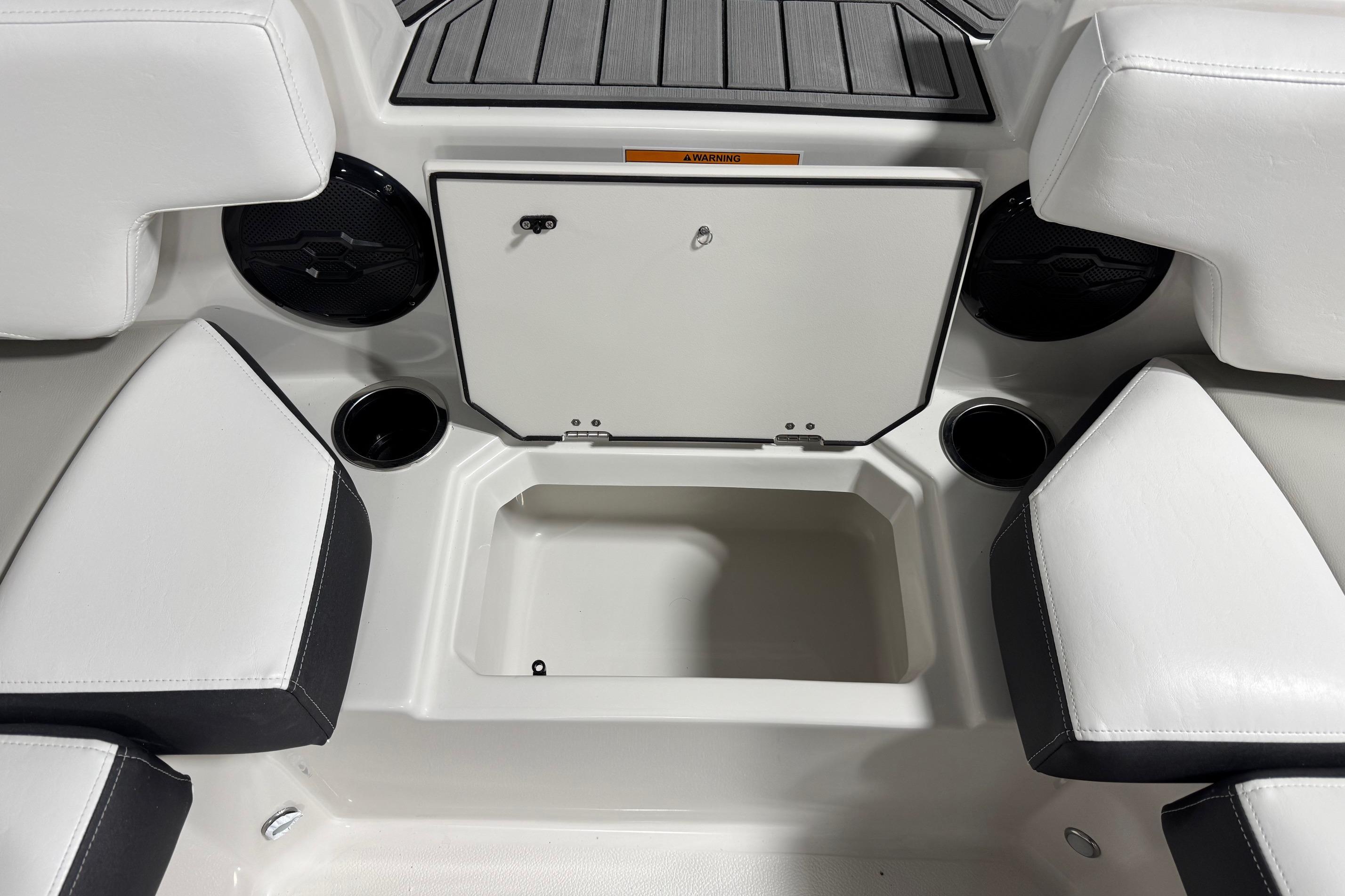 Interior seating and storage of 2026 Starcraft SVX 191 OB boat, featuring cup holders and speakers.