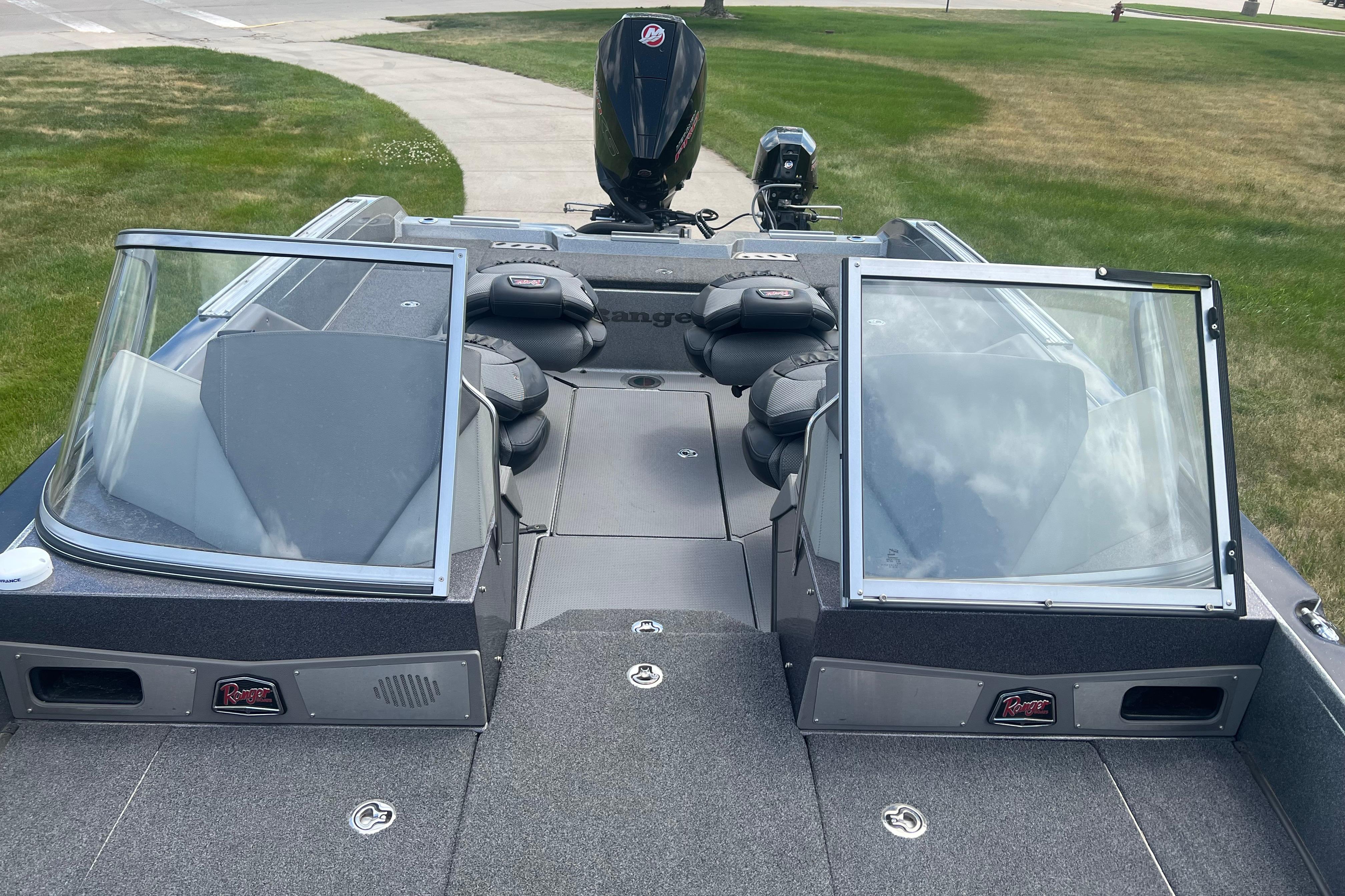 2023 Ranger 620FS Pro boat with dual windshields and seating, parked on grass.