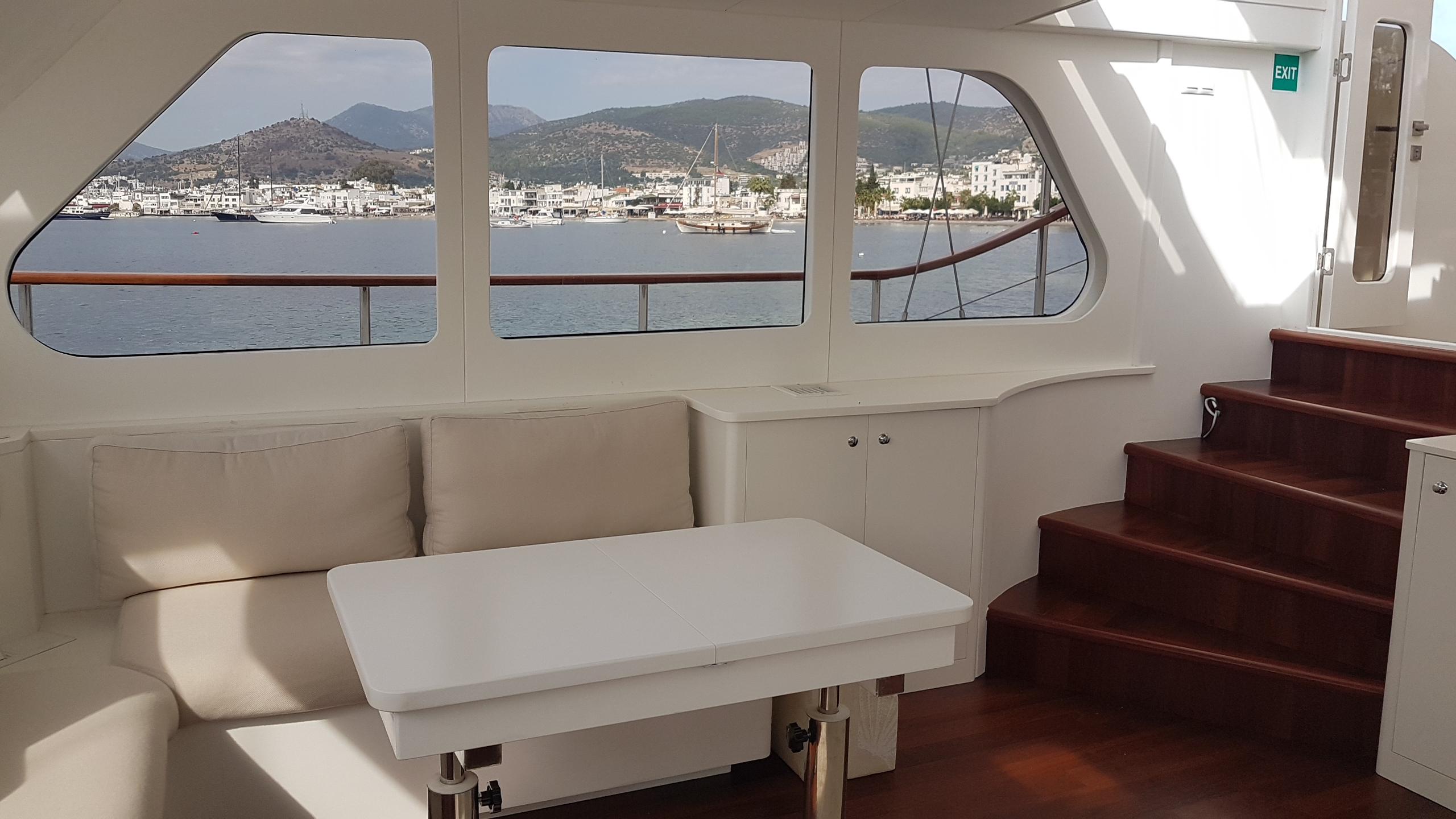 Interior of 2017 Custom GULET yacht with seating, table, and scenic ocean view.