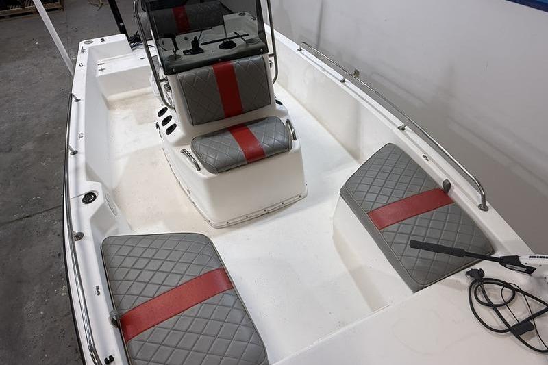 1996 Century 1800 Center Console boat with gray and red cushioned seating.