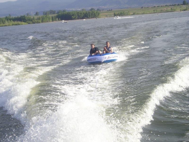 Two people tubing behind a 1997 Donzi 275LXC boat.