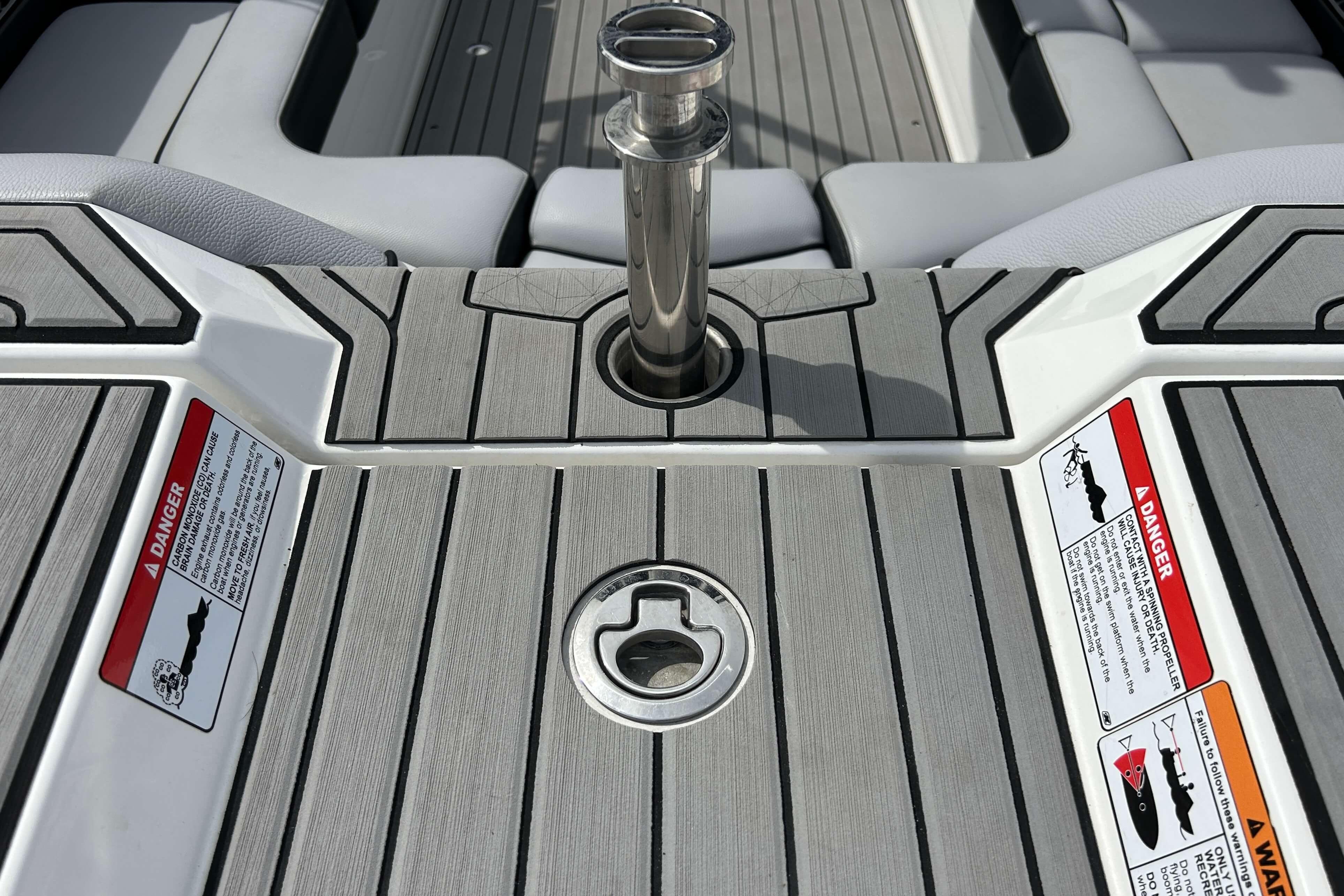 2021 Nautique Super Air Nautique GS24 boat deck with safety warnings and metal fixture.