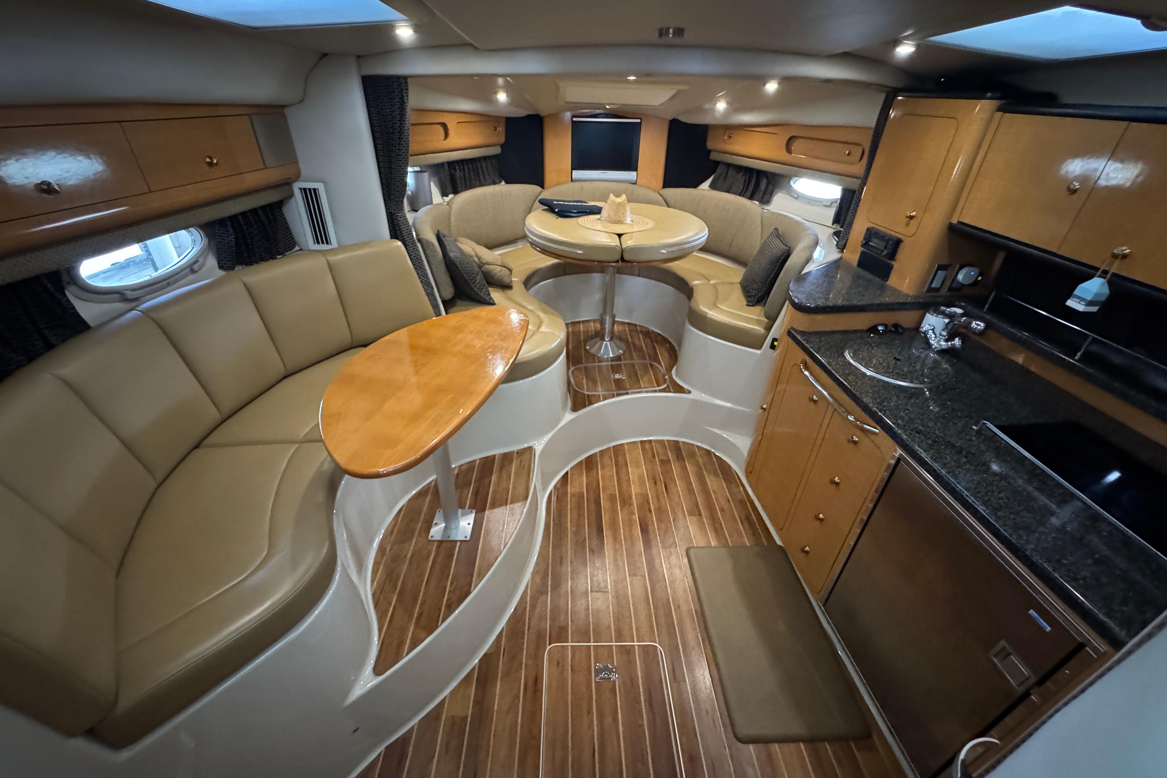 Luxurious interior of 2006 Chaparral 330 Signature yacht with elegant seating and kitchenette.