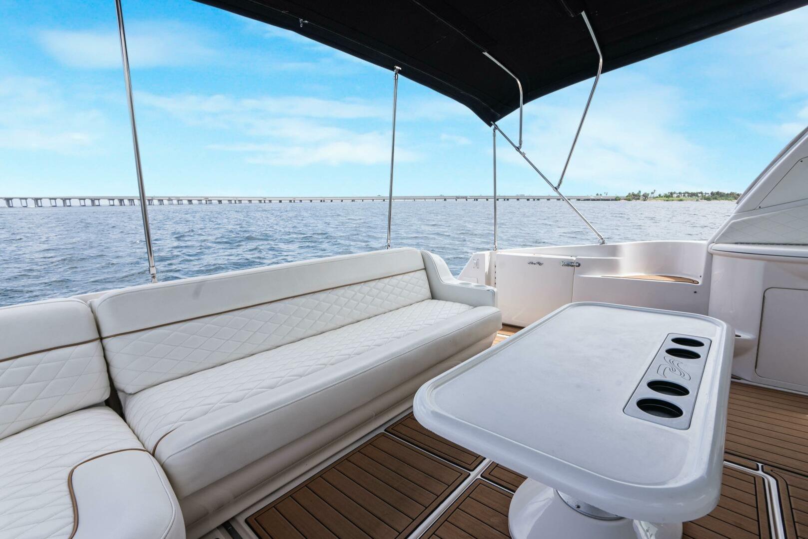 Luxurious 2003 Sea Ray Sundancer 460 yacht deck with seating, table, and ocean view.
