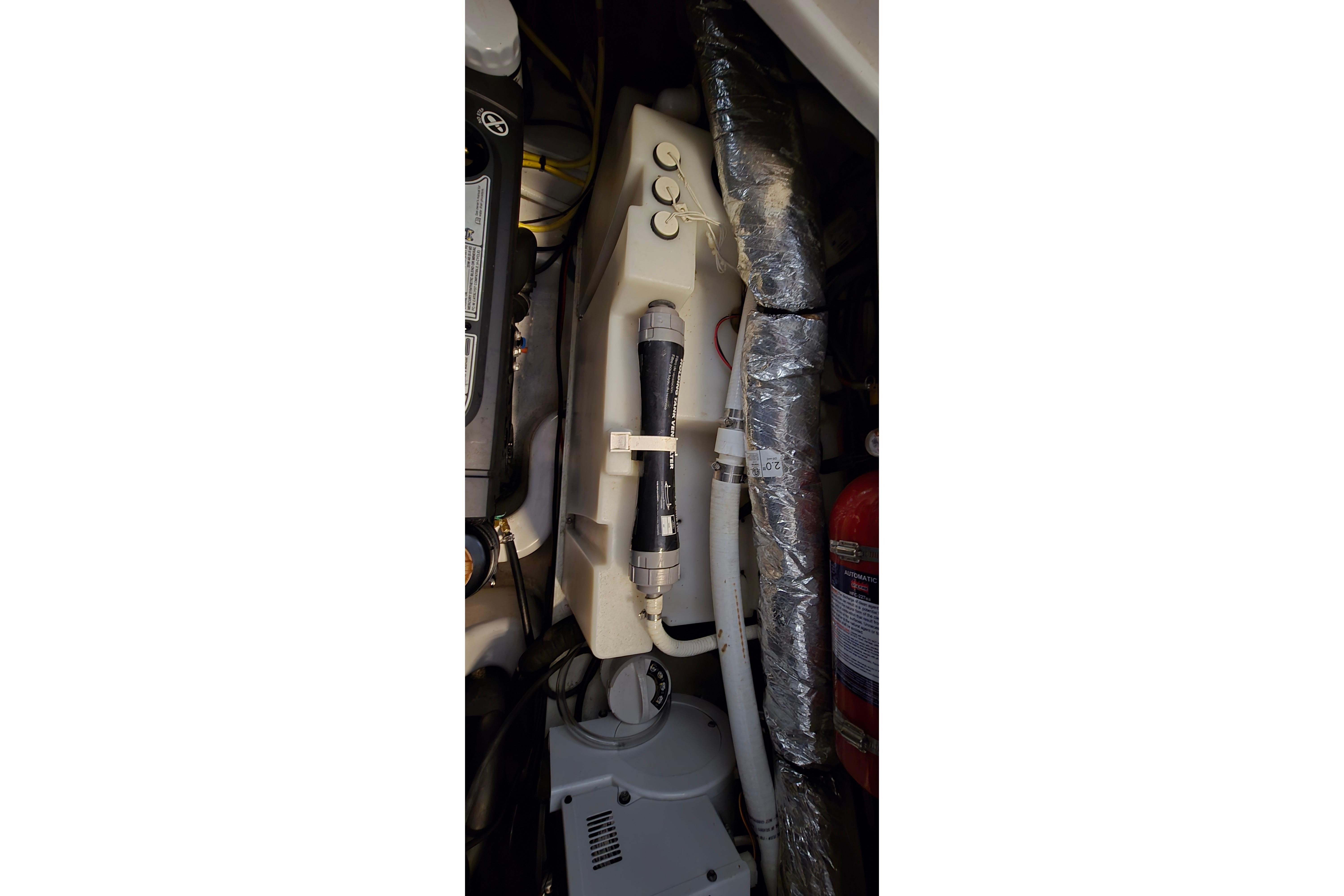 Engine compartment of 2018 Four Winns V355 boat, featuring mechanical components and fire extinguisher.