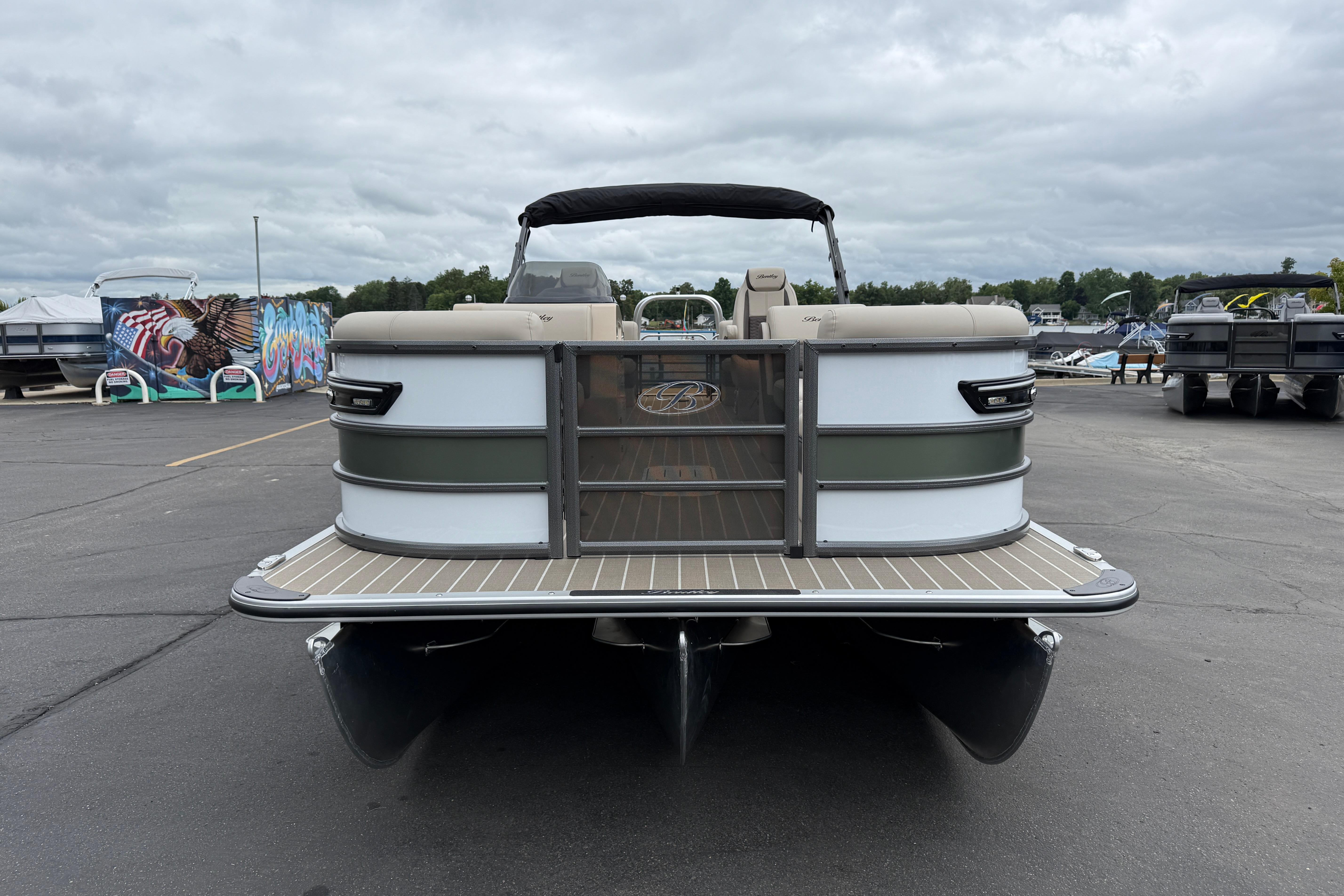 2026 Bentley Pontoons Elite 253 Admiral, rear view at marina, overcast sky.