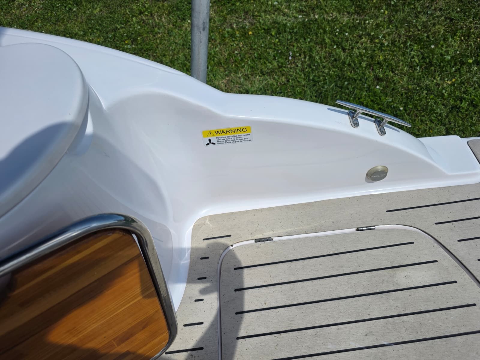 The image shows a boat deck with wood and metal accents.