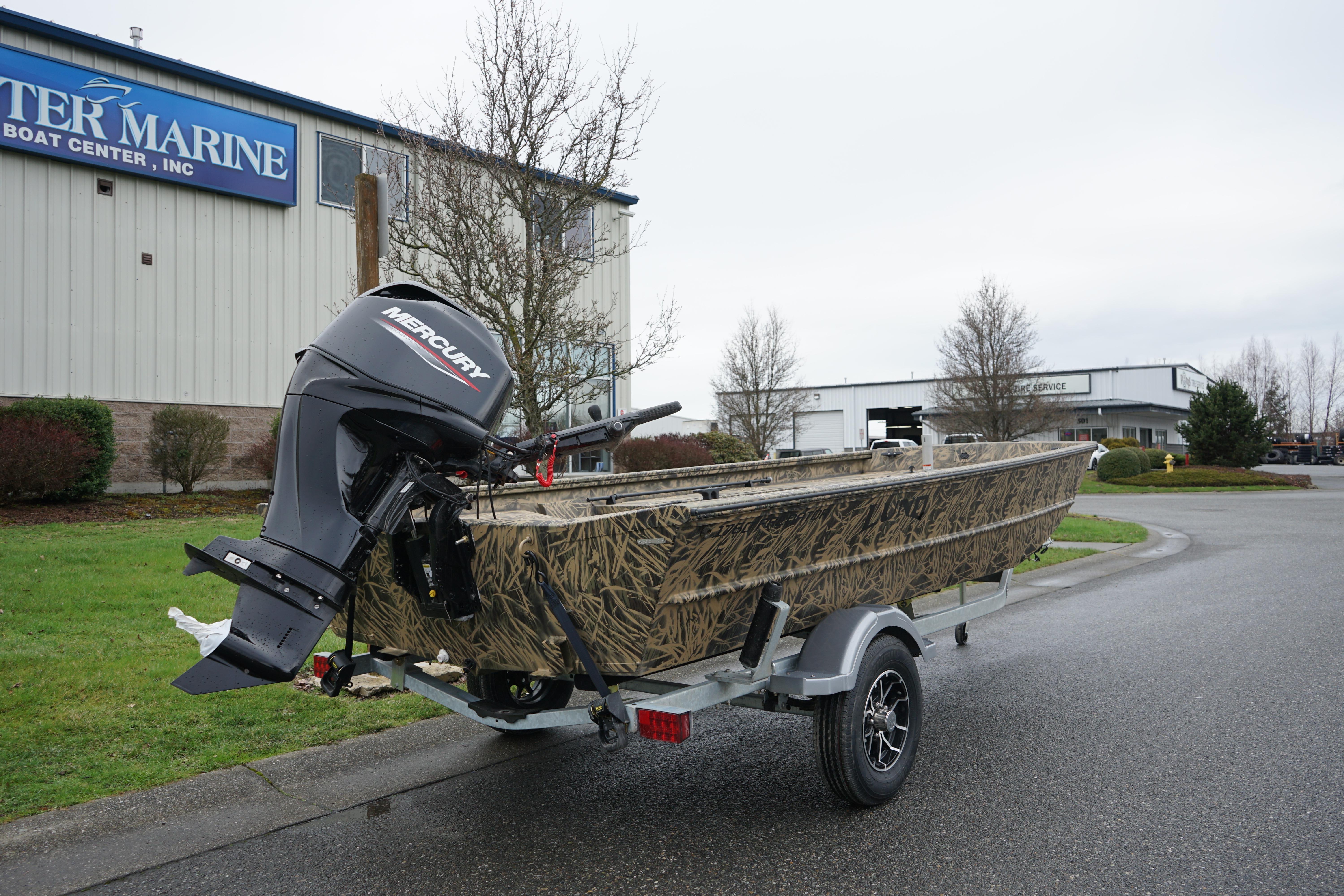 2024 Lund 1760 Predator Tiller boat with Mercury engine on trailer outside marine center.