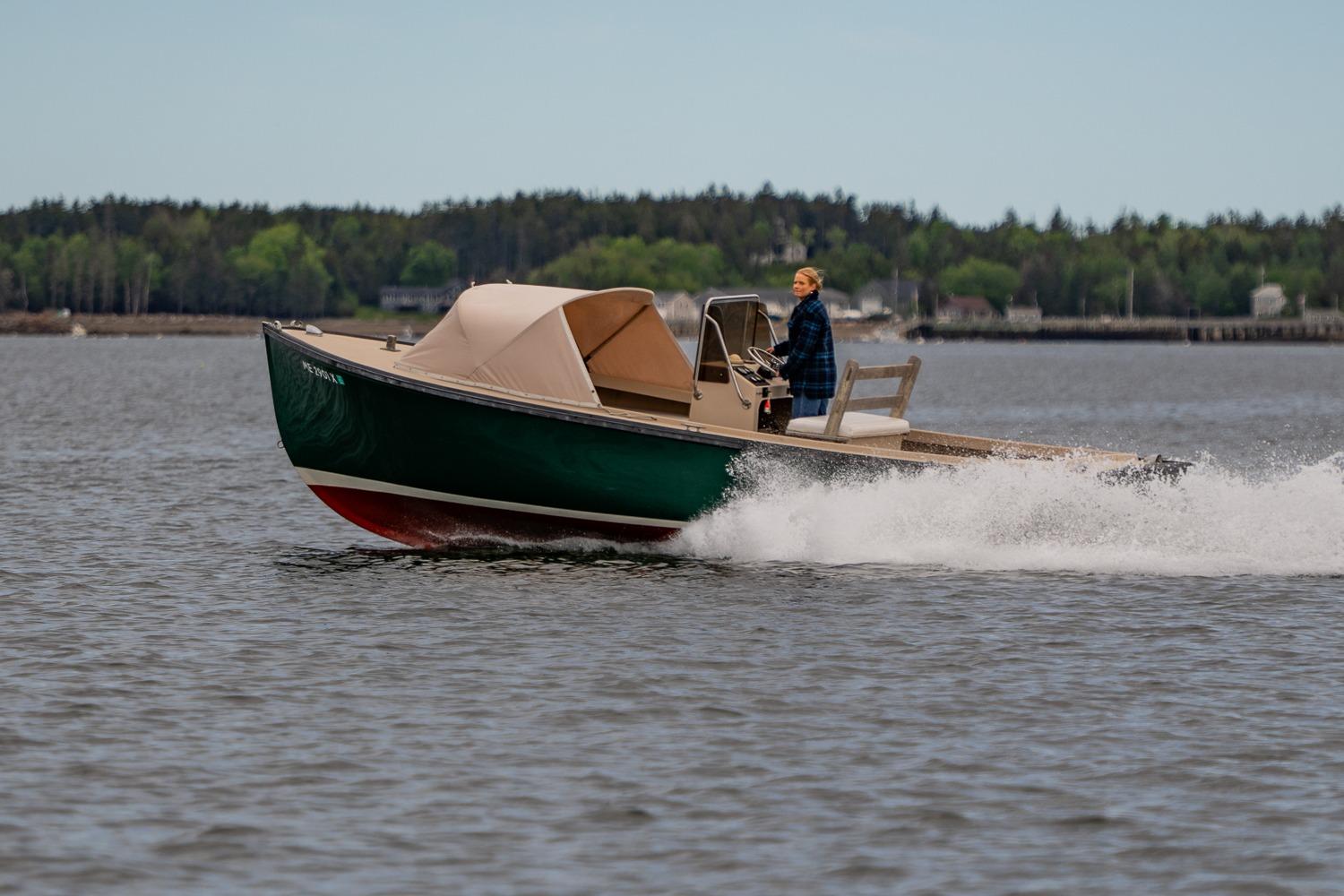 1989 Ellis 24 Open boat cruising on a lake with a person steering.