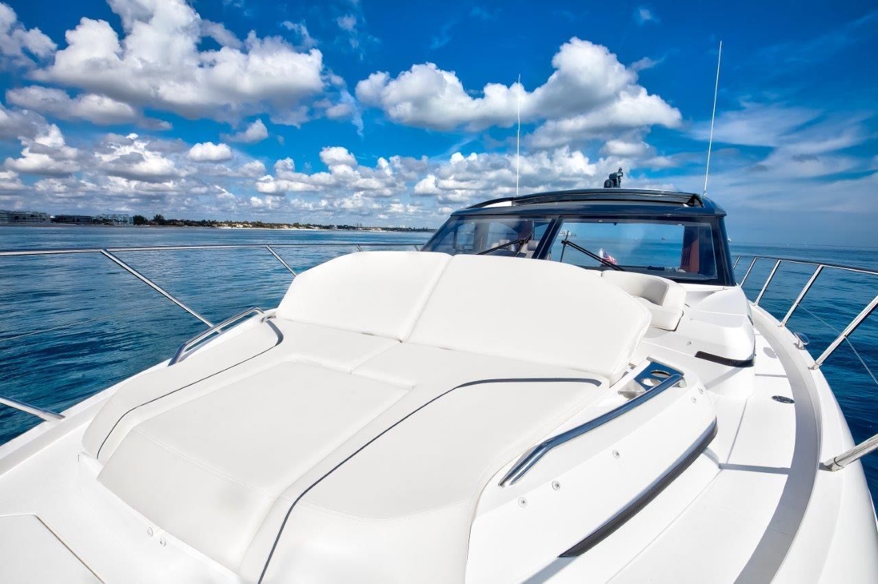 The image shows a luxury yacht with a spacious sun deck and clear blue skies.