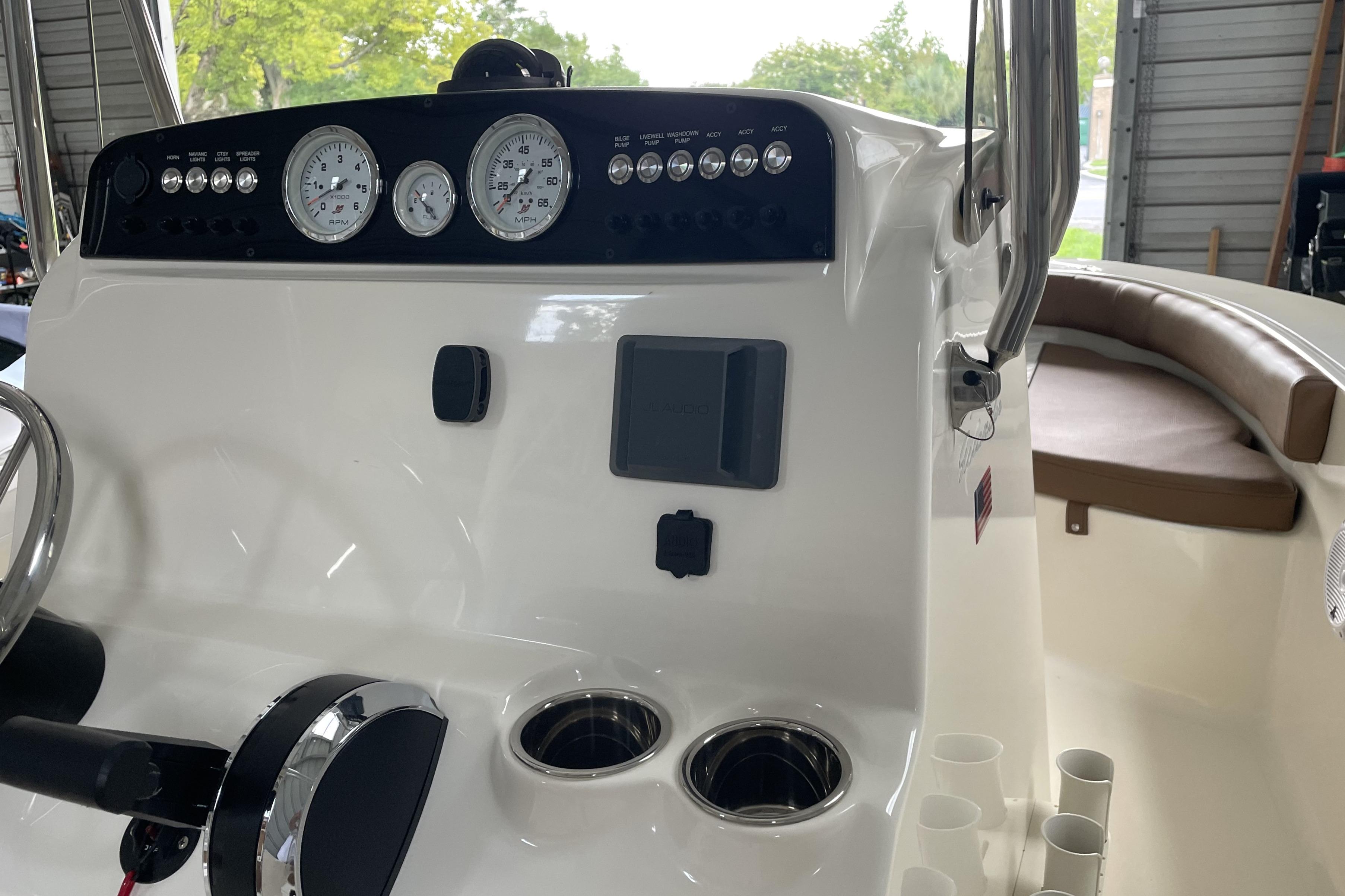 2024 Pioneer 180 Islander boat dashboard with gauges and controls in a garage setting.