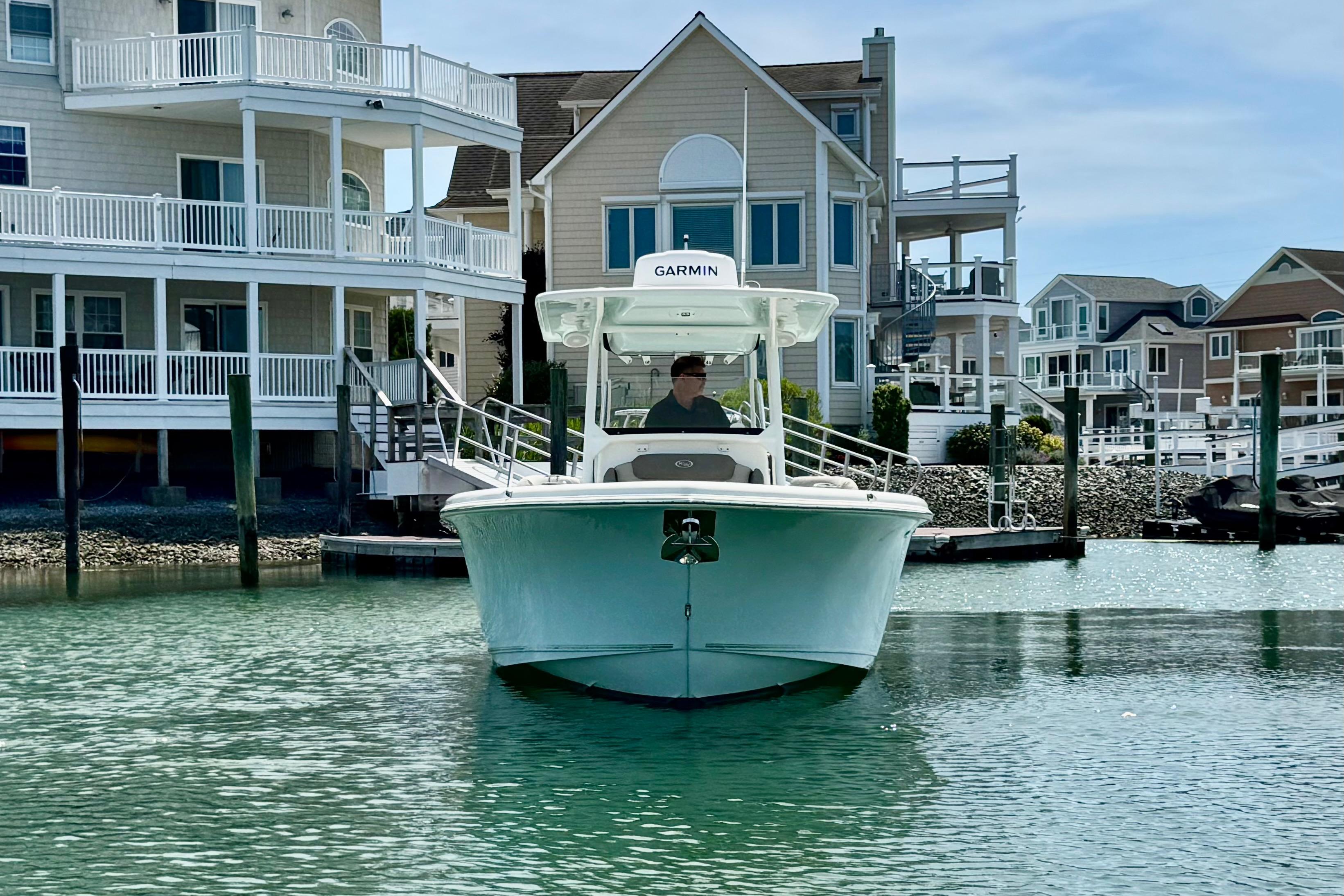 2022 Key West 263 FS boat docked near waterfront homes.