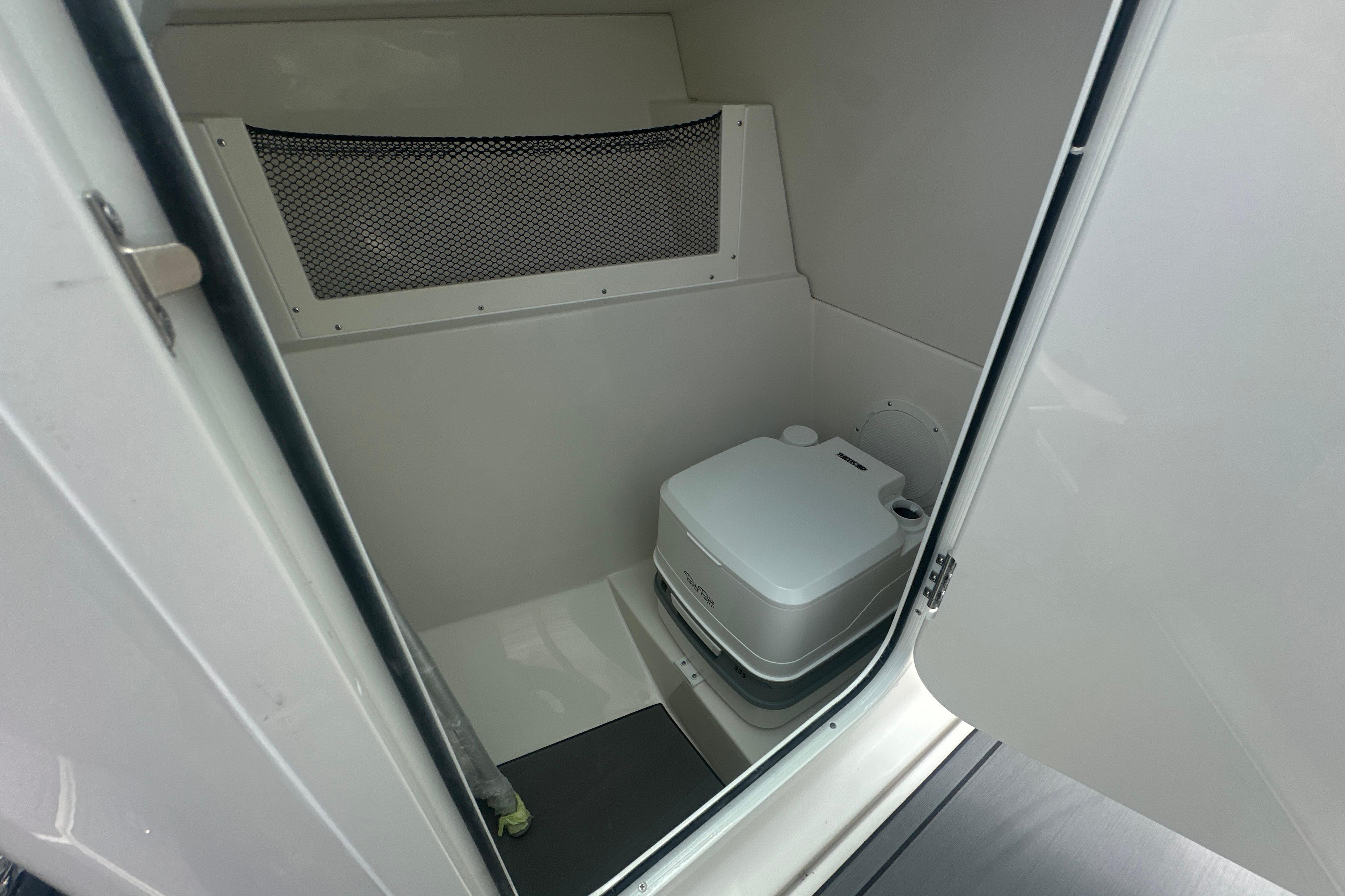 Interior of 2026 Sailfish 226 DC boat featuring a compact marine toilet.