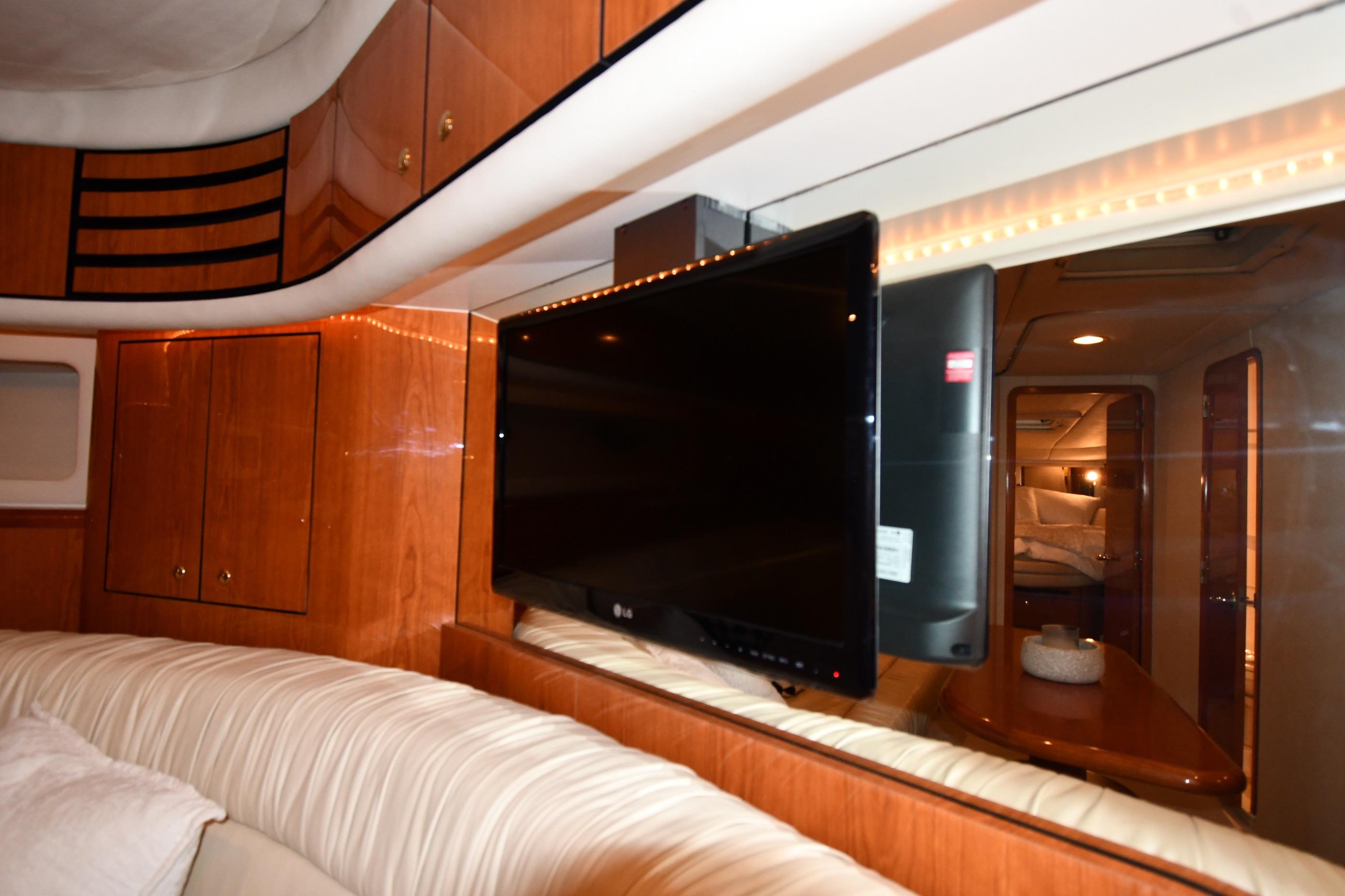 Luxurious interior of 2001 Sea Ray 540 Sundancer yacht with TV and wood cabinetry.