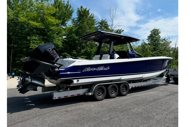 2024 Nor-Tech 400 Supersport boat on trailer, parked outdoors with trees in background.